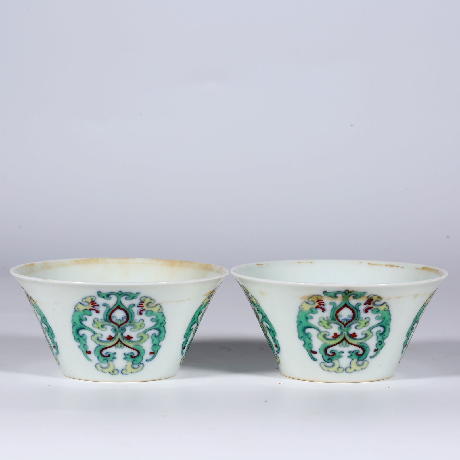 A SET OF HOOF-SHAPED PORCELAIN CUPS.: A Set of Contrasting-Color Hoof-Shaped Porcelain Cups, with Rounded Flowers Design.