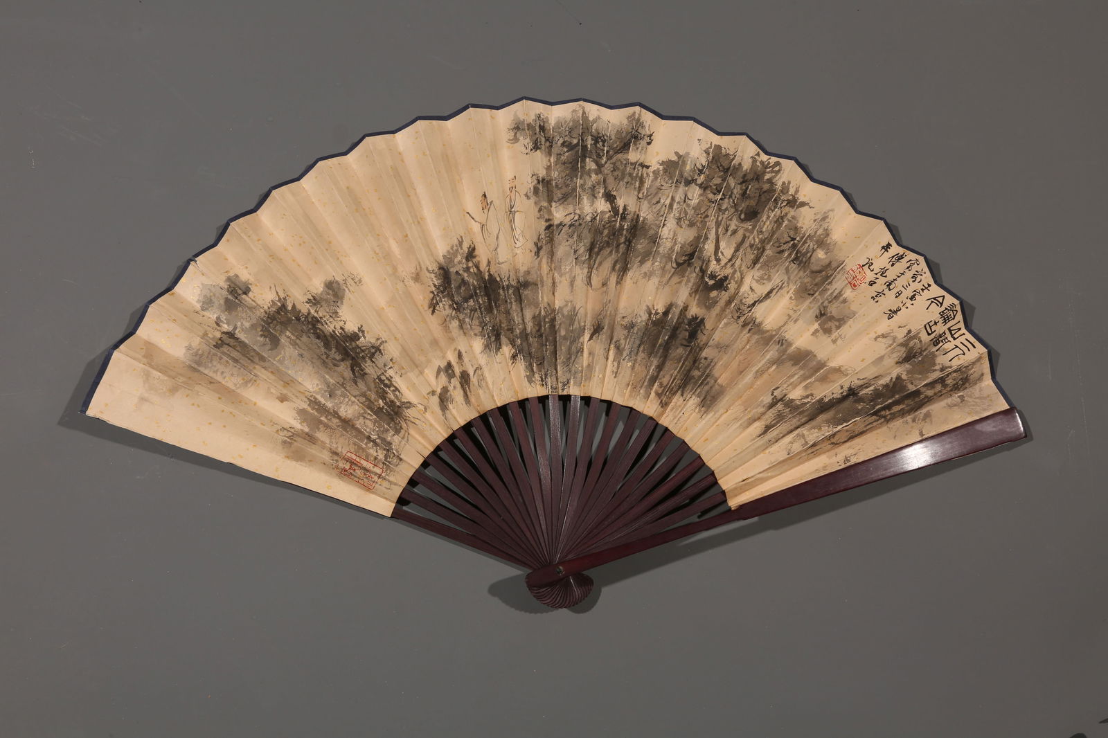 A PAPER FAN PAINTED BY FU BAOSHI WITH LANDSCAPE AND FIGURES.傅抱石: paper fan painted by Fu Baoshi with landscape and figures.傅抱石