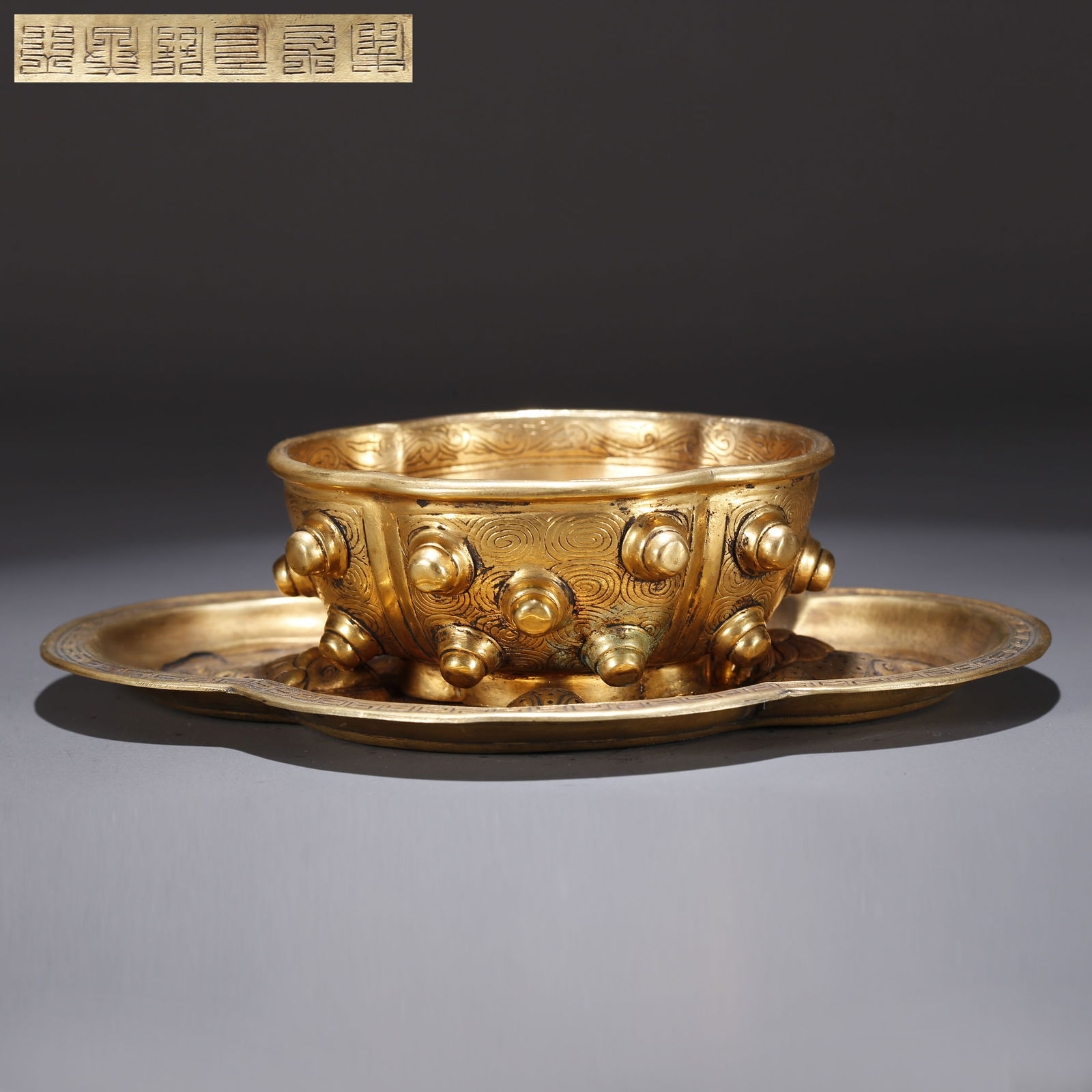 A GILT BRONZE TEA CUP WITH LION ROLLING EMBROIDERED BALL PATTERN: Gilt Bronze Tea Cup with Lion Rolling Embroidered Ball Pattern