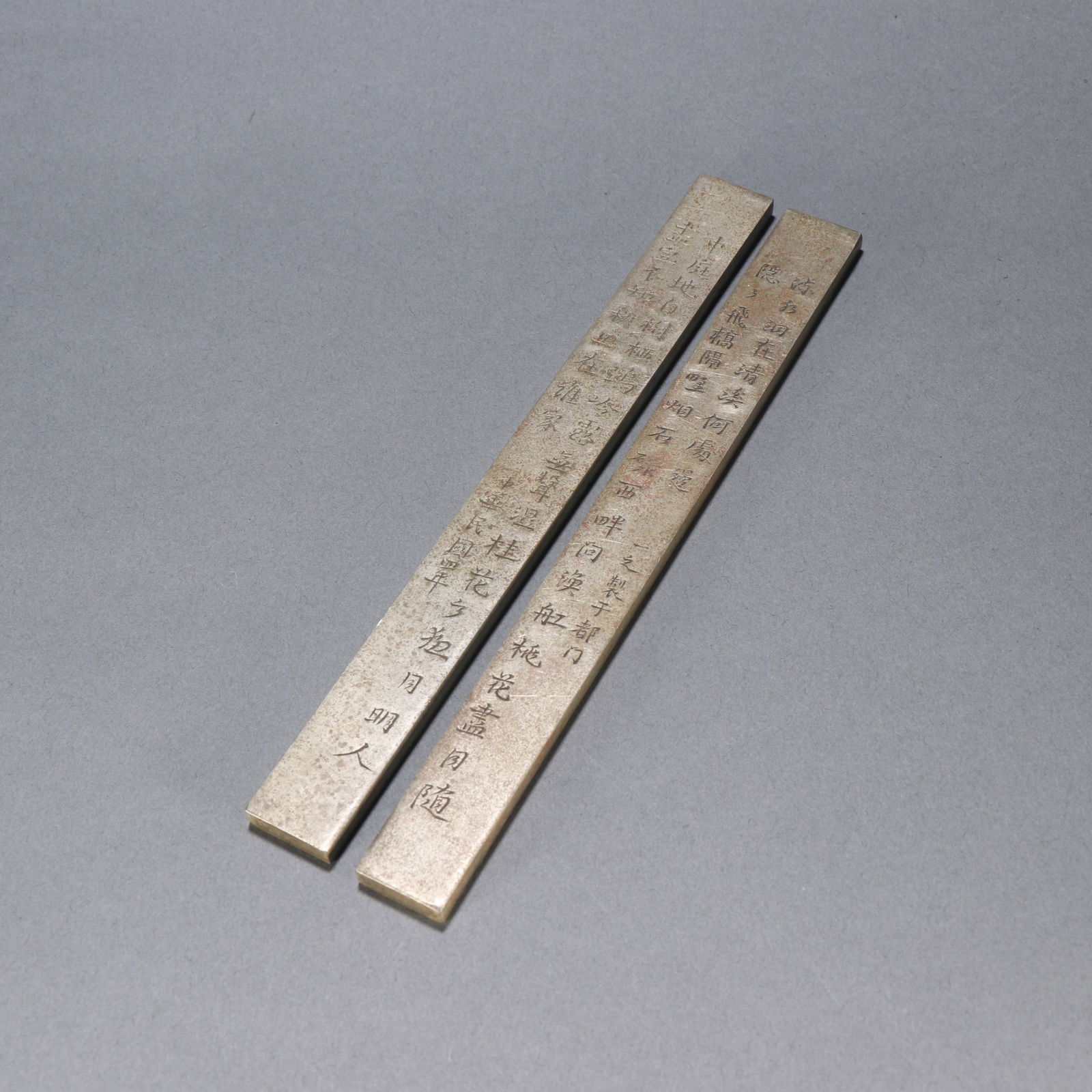 A PAIR OF BRONZE PAPERWEIGHTS ENGRAVED WITH POETRY: Pair of bronze paperweights engraved with poetry