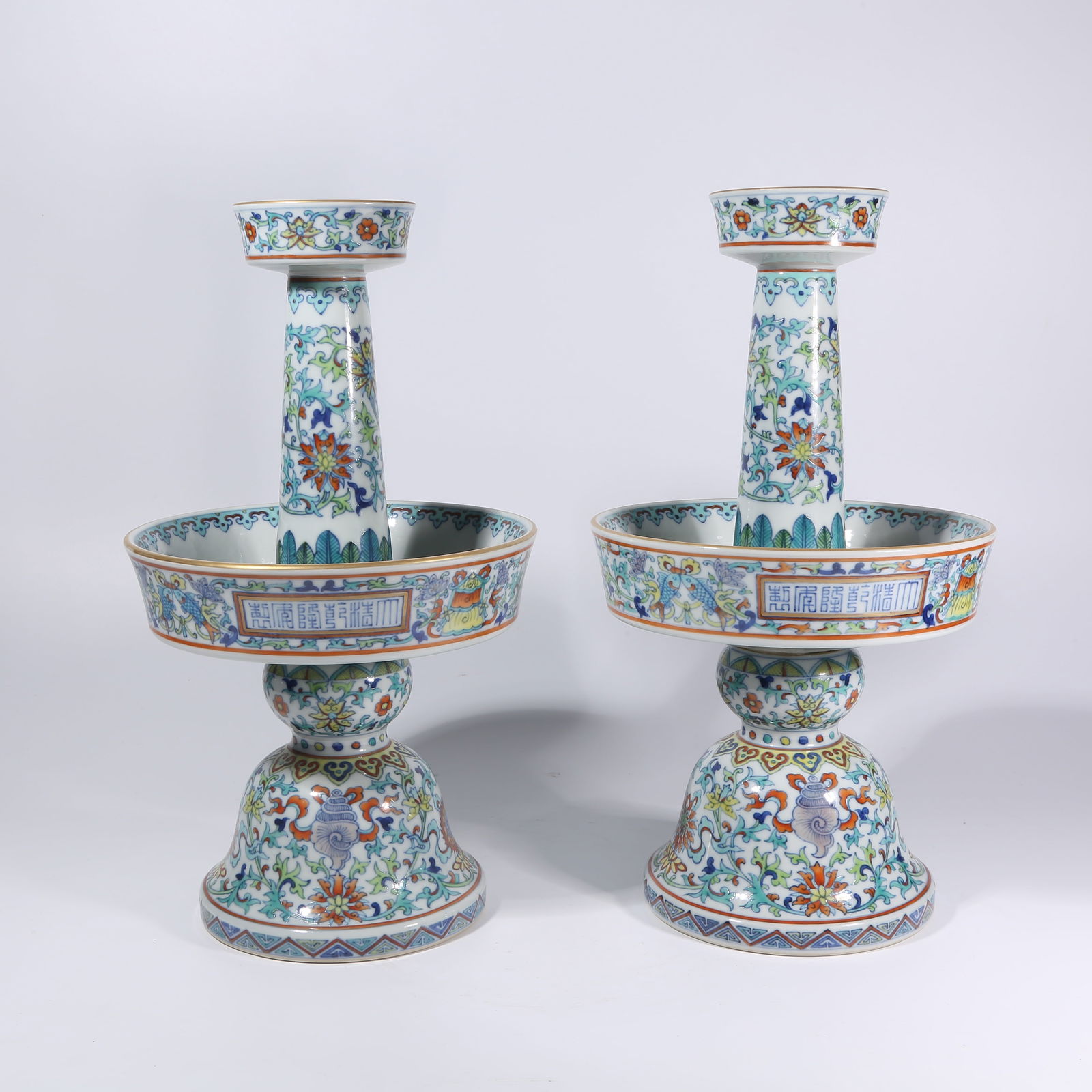 A DOUCAI PASSIONFLOWER WITH EIGHT AUSPICIOUS SYMBOLS CANDLESTICKS, A SET: Doucai Passionflower with Eight Auspicious Symbols Candlesticks, a Set