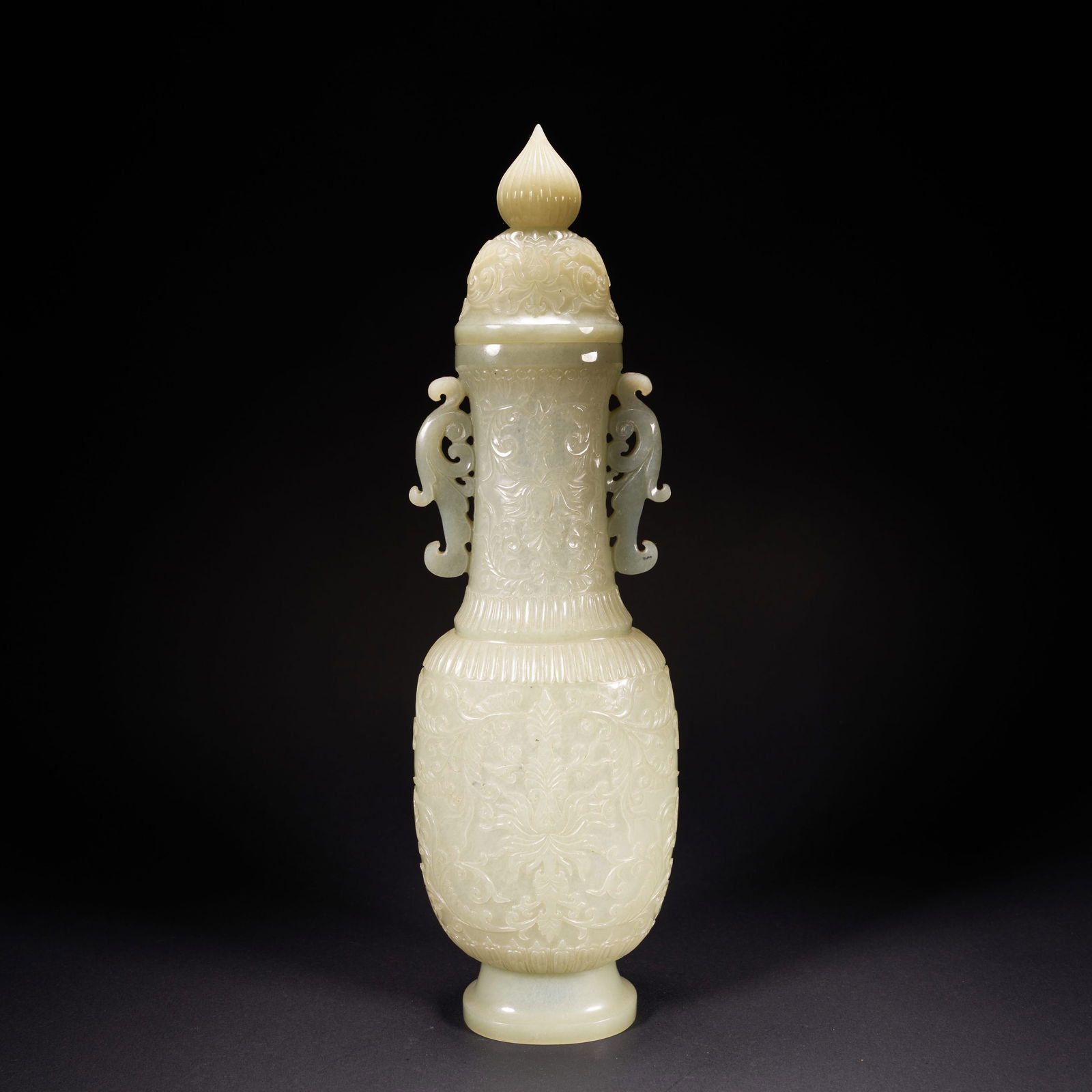 A HETIAN JADE VASE WITH FLORAL-AND-GRASS MOTIFS AND RUYI-SHAPED HANDLES, QING DYNASTY: Hetian jade vase with floral-and-grass motifs and ruyi-shaped handles, Qing Dynasty
