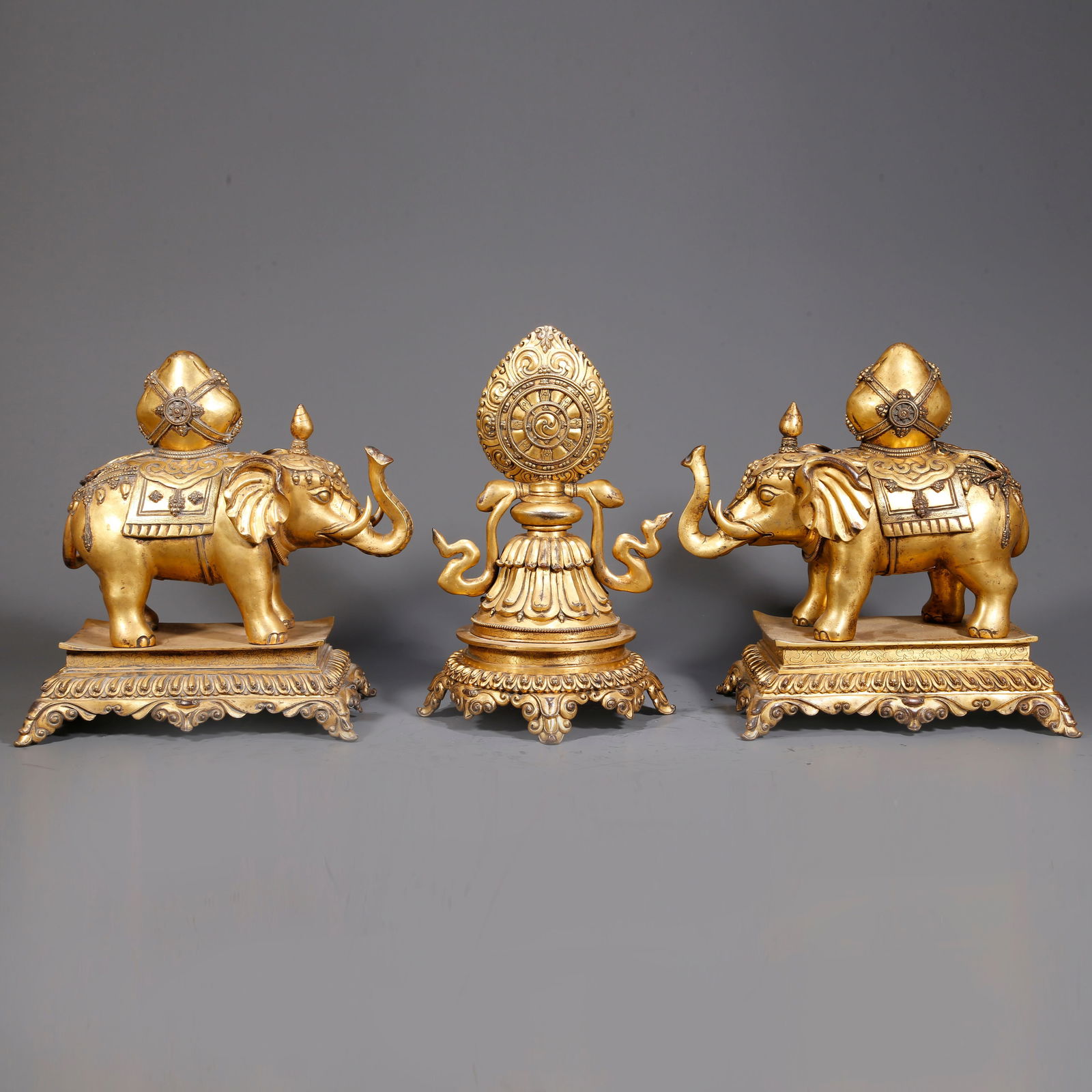 A GILDED BRONZE DHARMA WHEEL ORNAMENTS (A SET): Gilded bronze Dharma Wheel ornaments (a set)