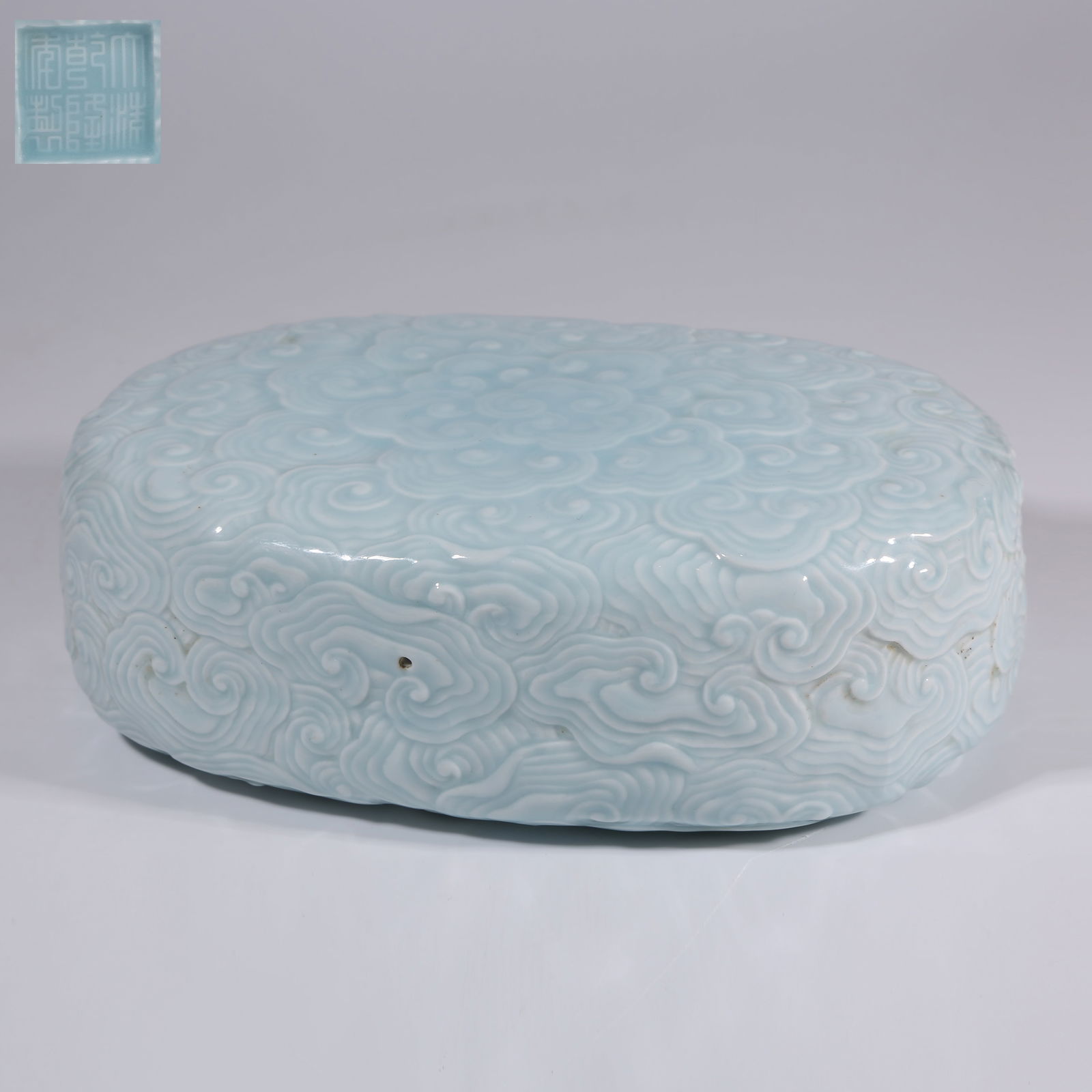 A SKY-BLUE GLAZE PAPERWEIGHT WITH RUYI-CLOUD MOTIFS: Sky-Blue Glaze Paperweight with Ruyi-Cloud Motifs