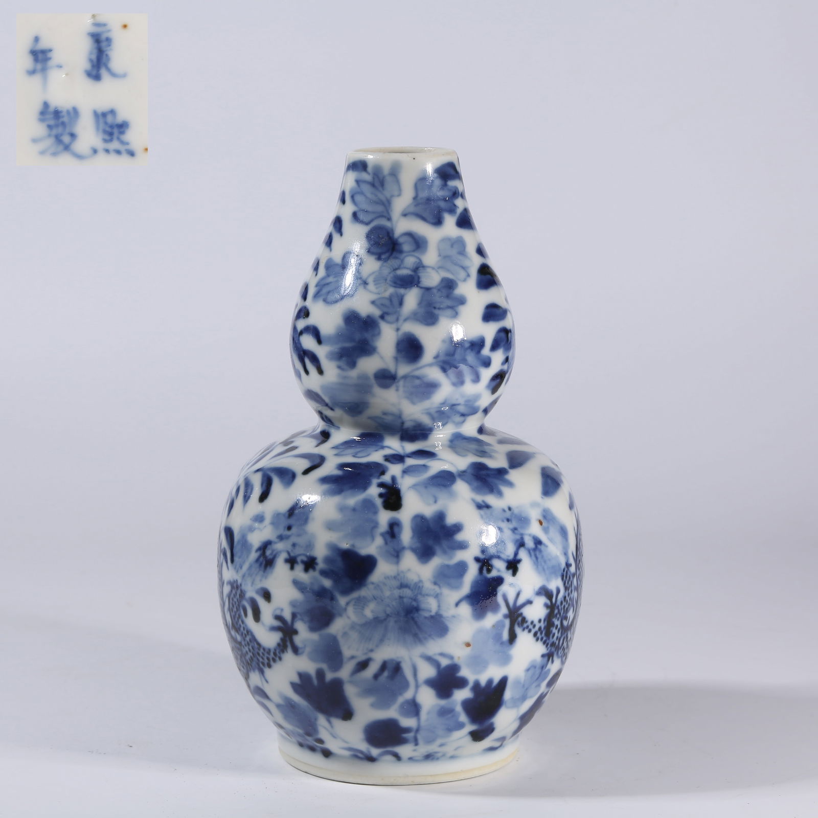 A BLUE-AND-WHITE GOURD-SHAPED VASE WITH DRAGON PASSING THROUGH FLOWERS MOTIF (1 of 9)