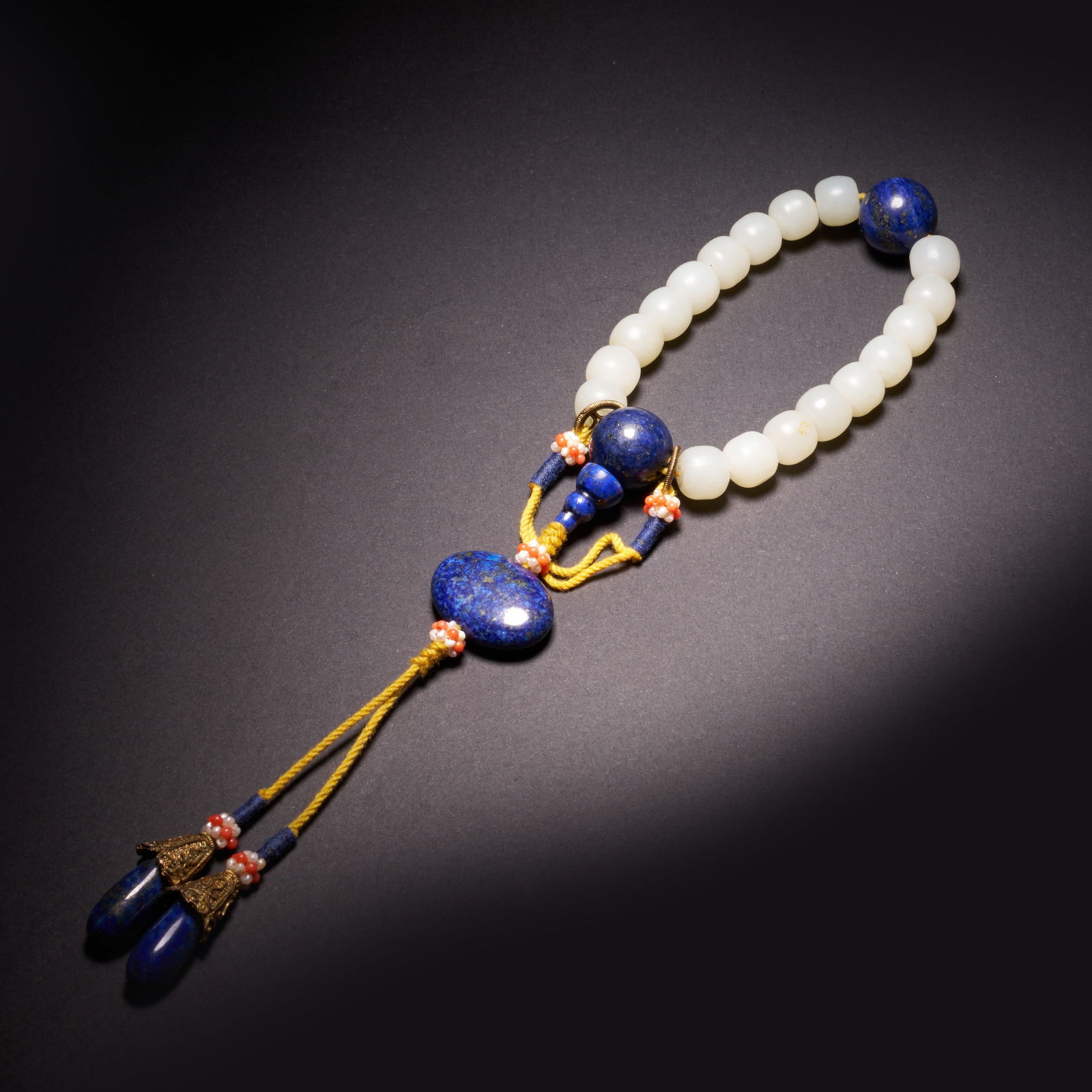 A HETIAN JADE "EIGHTEEN ARHATS' BEADS" HAND-HELD PIECE, QING DYNASTY (1 of 10)