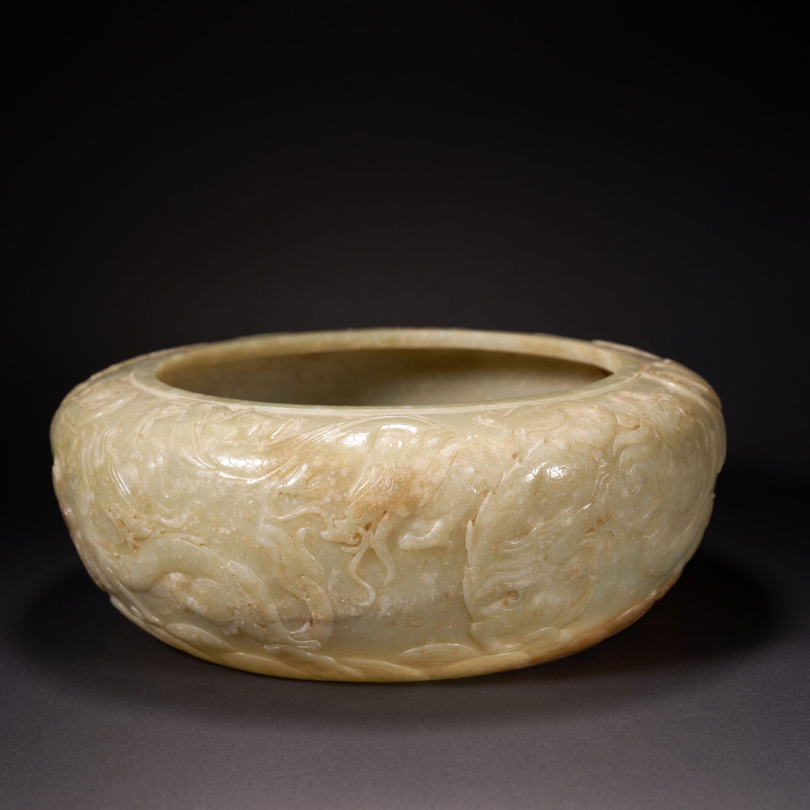 A HETIAN JADE LARGE CIRCULAR BASIN WITH DRAGON MOTIFS, HAN DYNASTY (1 of 9)