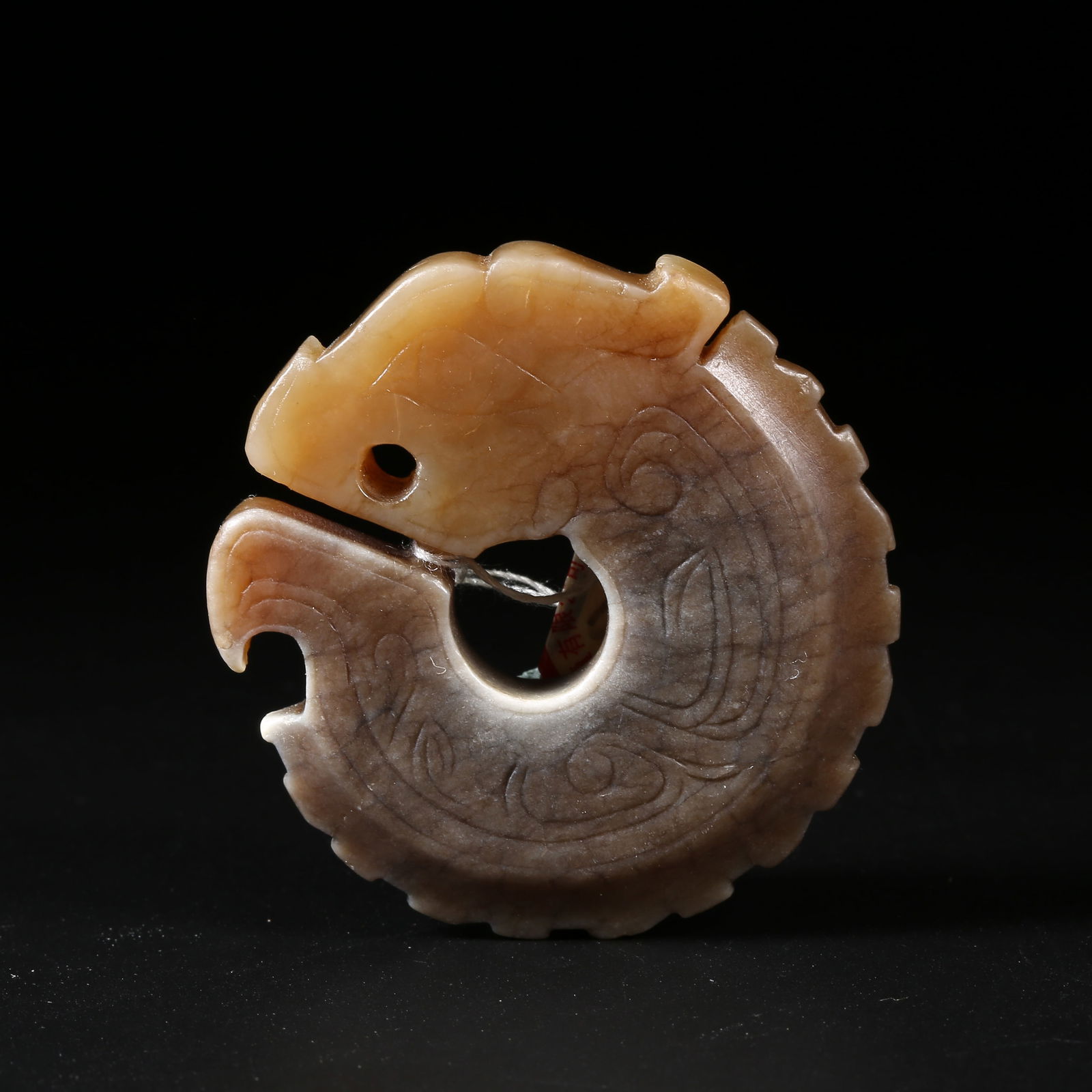 A HIGH-ANTIQUITY JADE PENDANT OF A DRAGON BITING ITS TAIL (1 of 9)