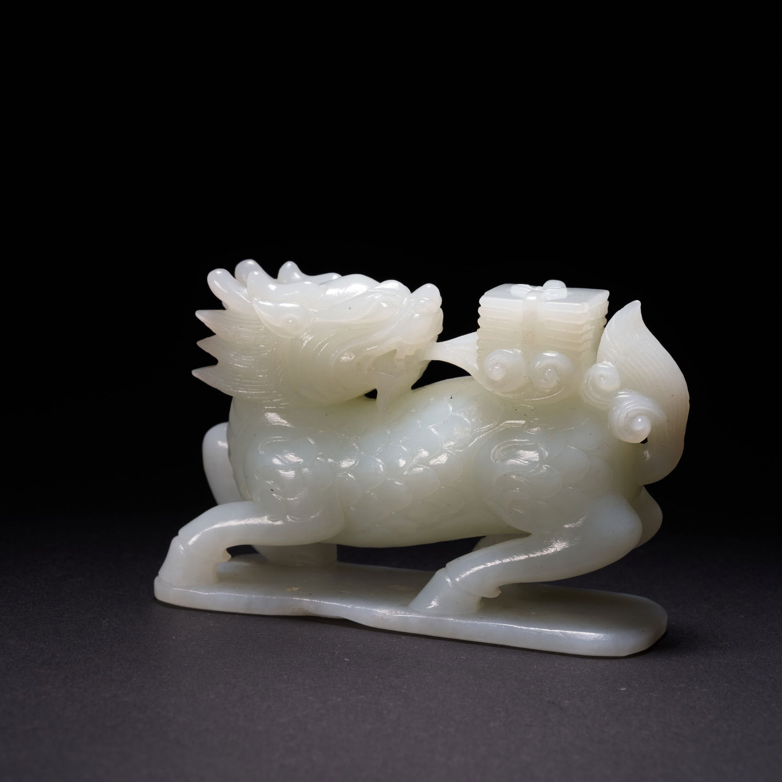 A HETIAN JADE "QILIN CARRYING A BOOK" ORNAMENT, QING DYNASTY (1 of 8)