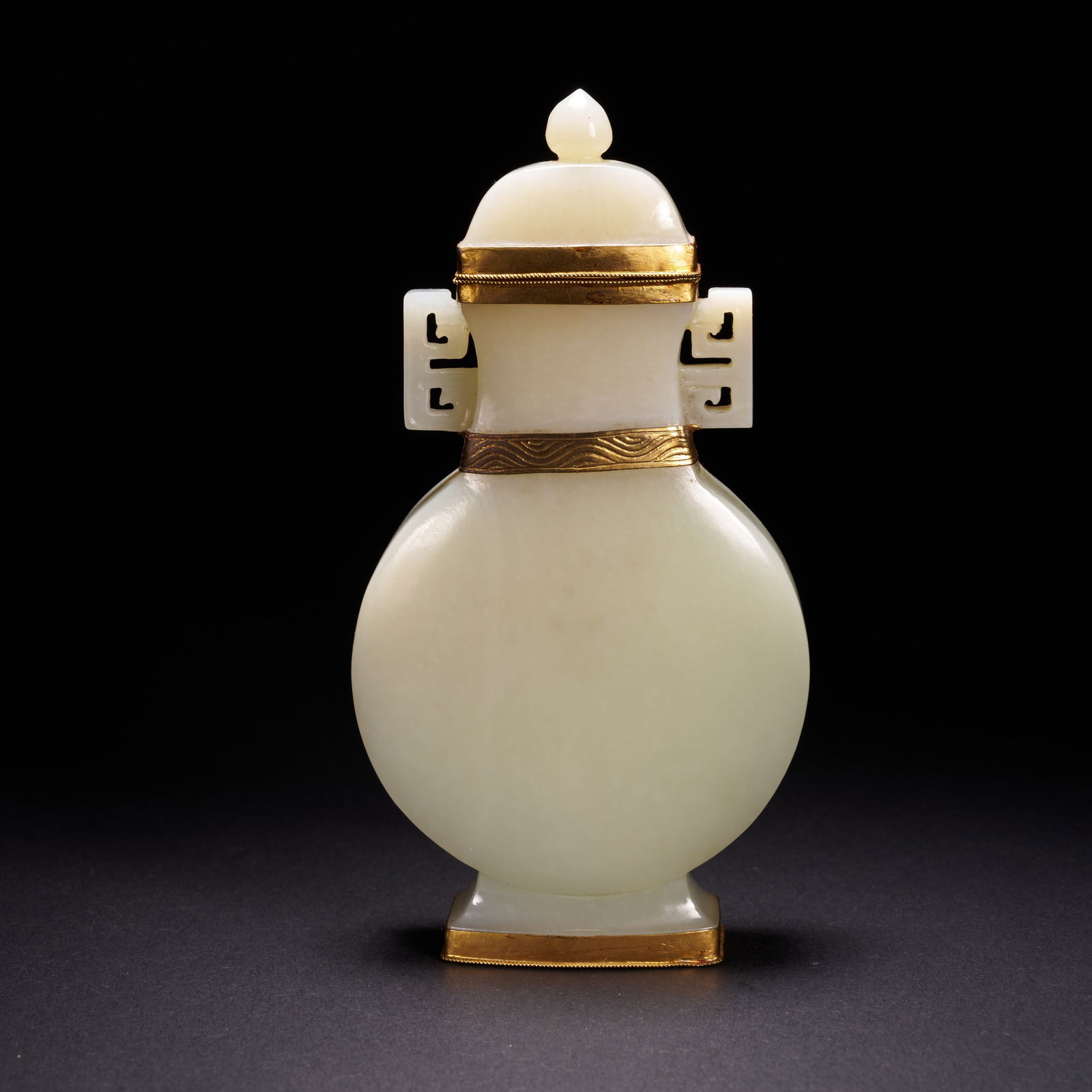 A HETIAN JADE FLATTENED VASE WITH TWIN HANDLES AND GILT MOUNTS, QING DYNASTY: Hetian jade flattened vase with twin handles and gilt mounts, Qing Dynasty