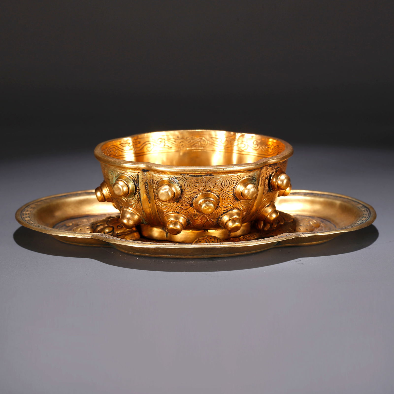 A GILT BRONZE TEA CUP WITH LION PLAYING WITH EMBROIDERED BALL DESIGN (1 of 10)
