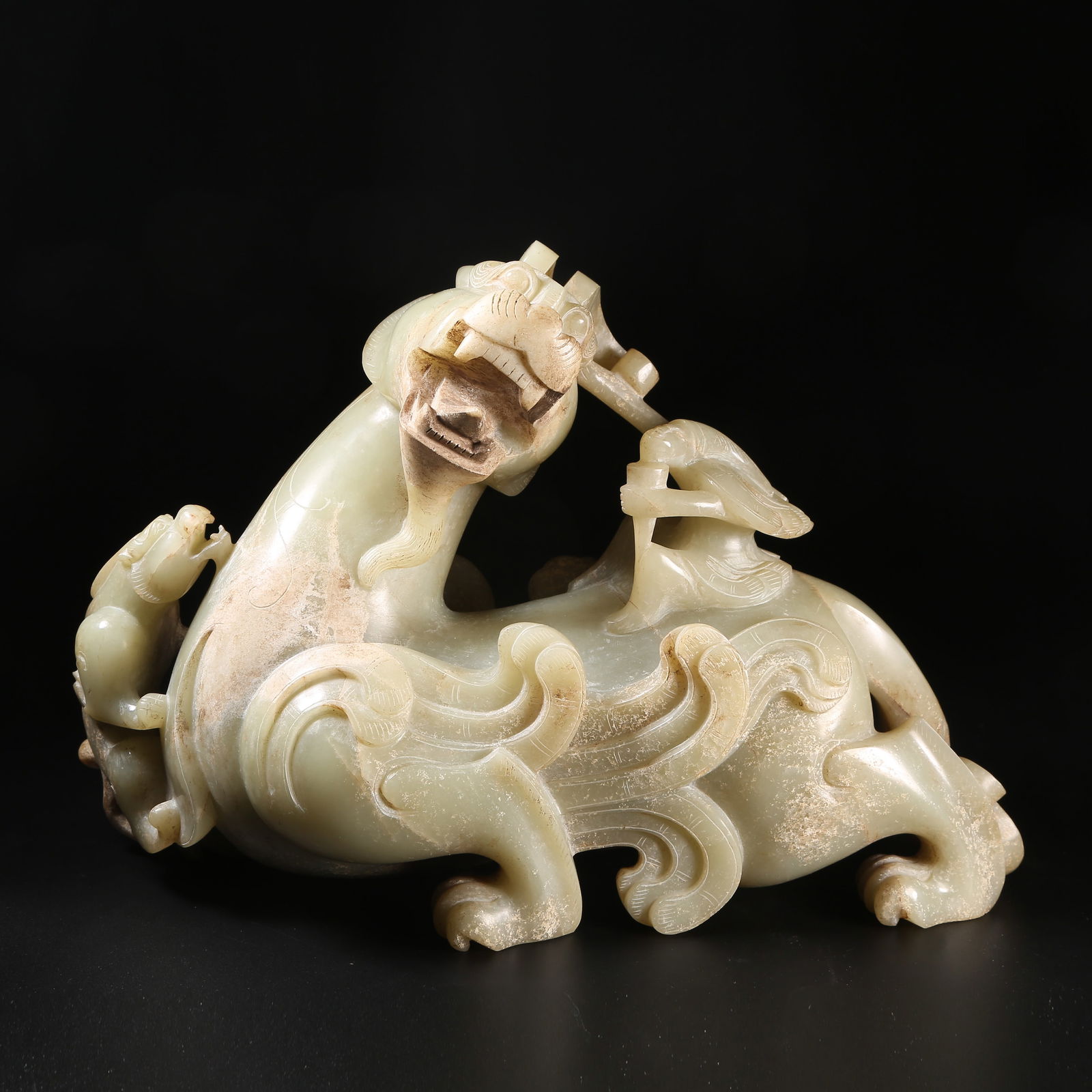 A PRE-HAN ANCIENT JADE WINGED FIGURE RIDING BEAST FIGURINE (1 of 9)