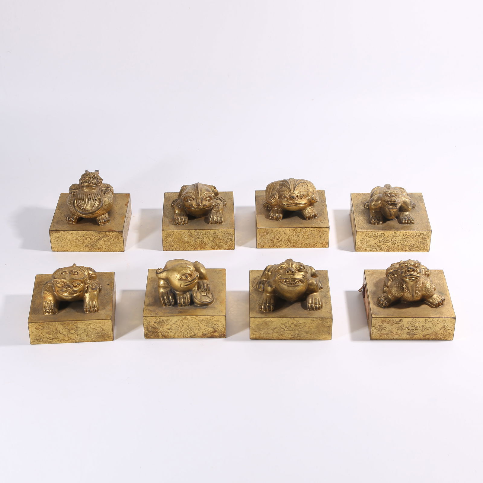 A QING DYNASTY GILT-BRONZE BEAST-HANDLE SEALS, SET (1 of 11)