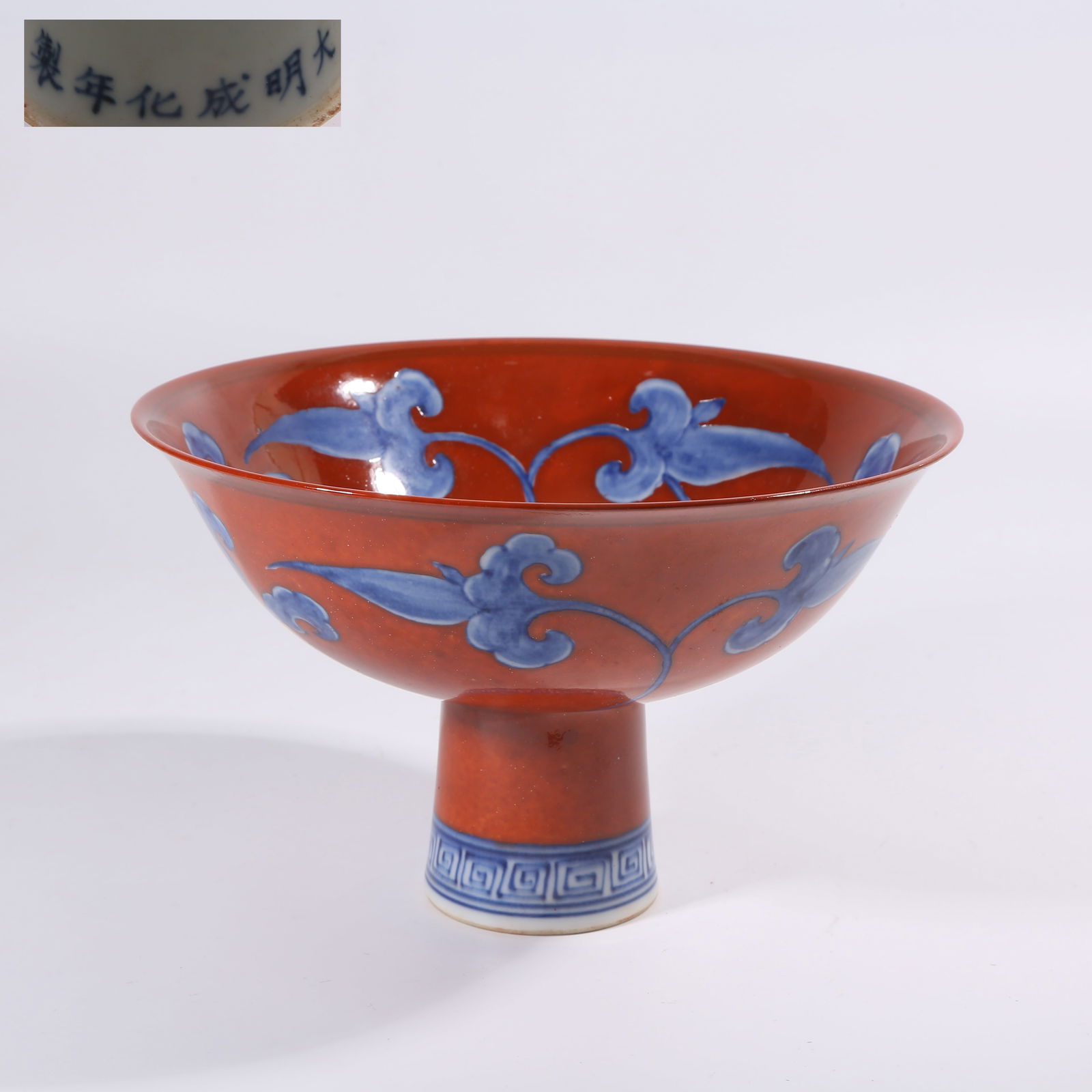 A MING DYNASTY CHENGHUA RED-GROUND BLUE-AND-WHITE HIGH-FOOT BOWL WITH DAYLILY PATTERN: Ming Dynasty Chenghua Red-Ground Blue-and-White High-Foot Bowl with Daylily Pattern