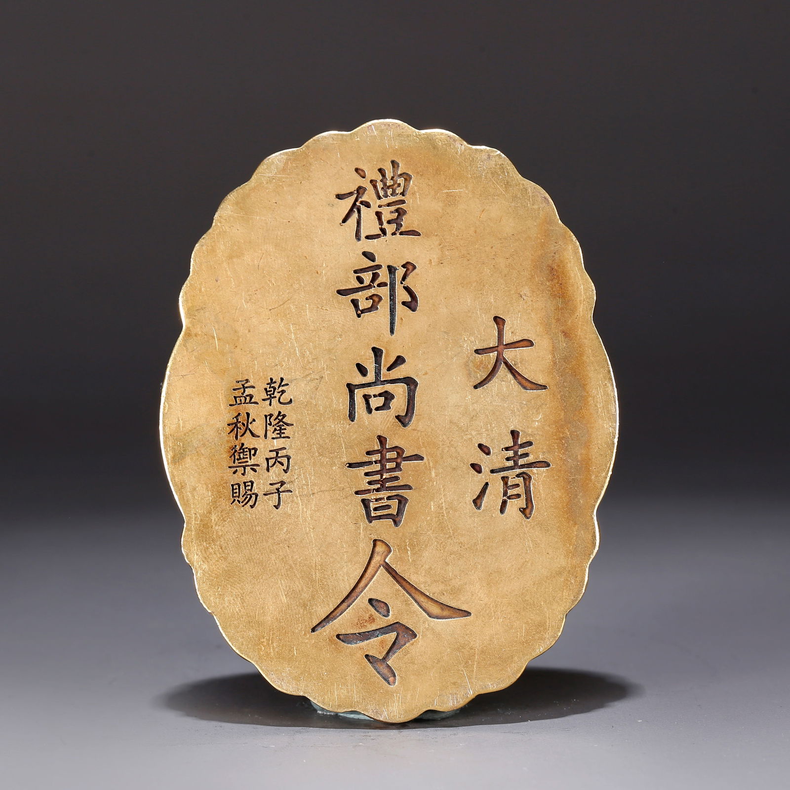 A GILT BRONZE TOKEN WITH CLOUD-AND-DRAGON DESIGN: Gilt bronze token with cloud-and-dragon design