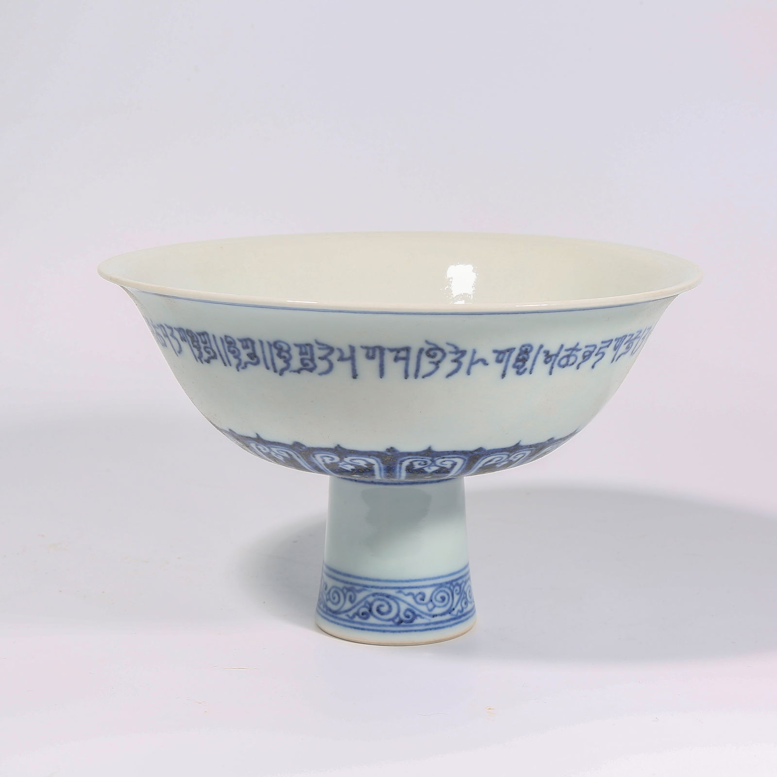 A BLUE AND WHITE SANSKRIT-SCRIPT STEM BOWL: Blue and white Sanskrit-script stem bowl