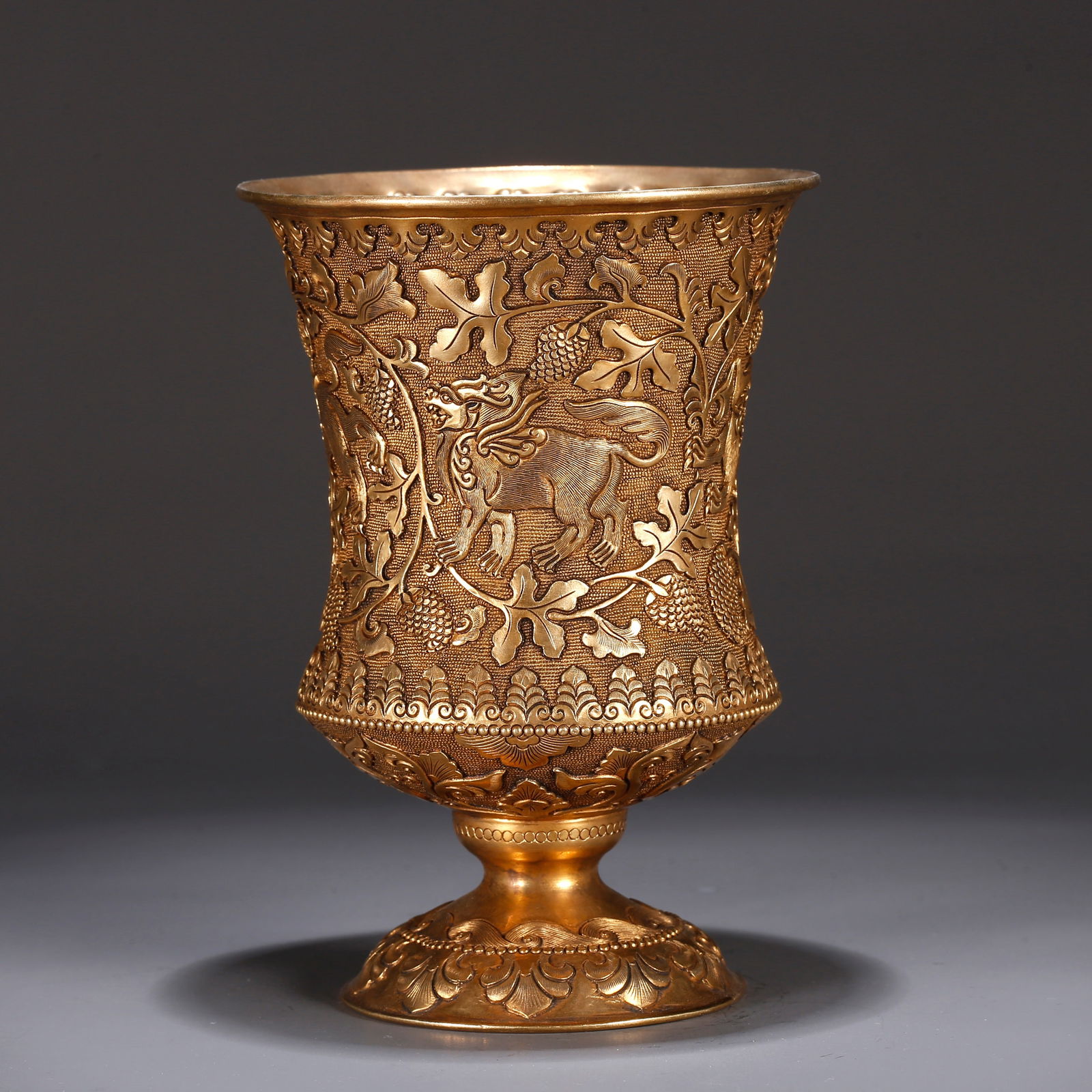 A GILT BRONZE CUP WITH AUSPICIOUS BEAST PATTERN: Gilt Bronze Cup with Auspicious Beast Pattern