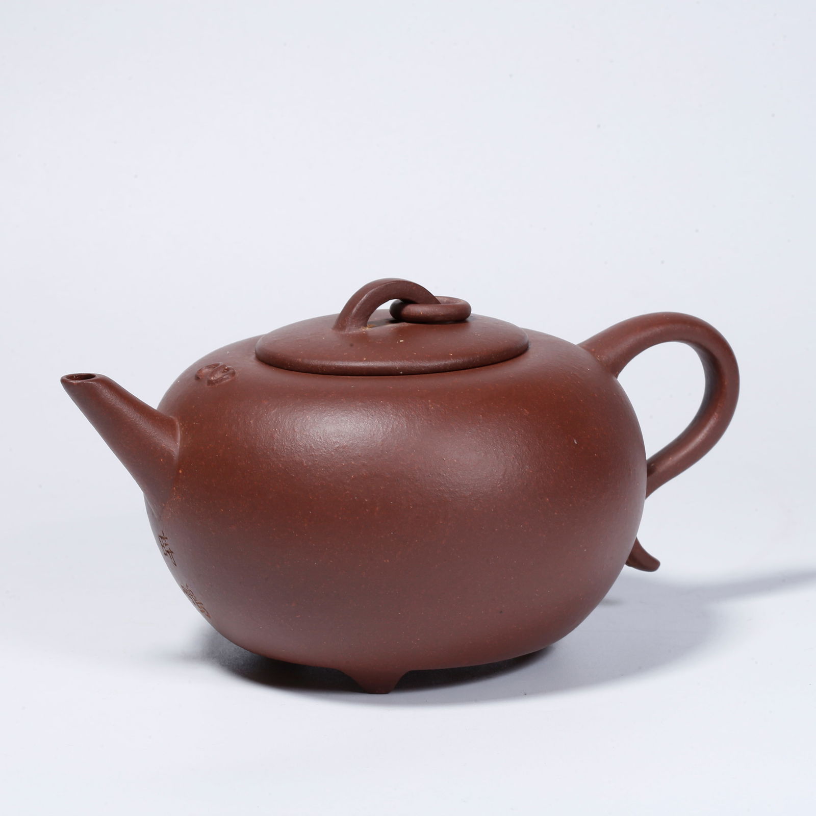A YIXING ZISHA TEAPOT WITH CARVED DESIGN: Yixing zisha teapot with carved design