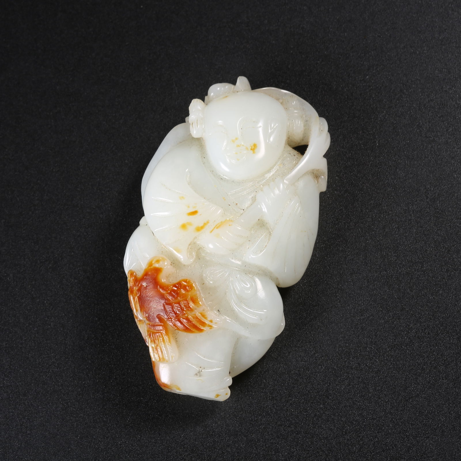 A HETIAN JADE PENDANT OF A CHILD HOLDING A LOTUS: Hetian Jade Pendant of a Child Holding a Lotus
