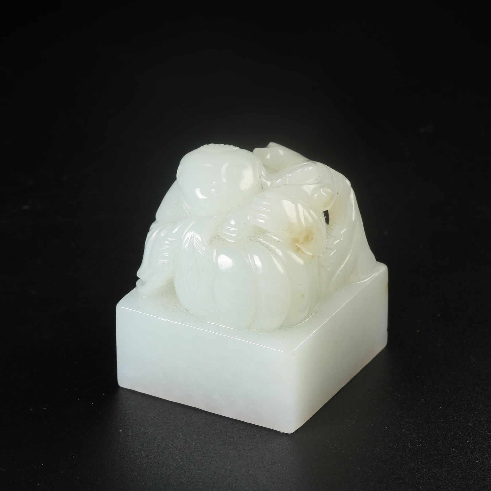 A HETIAN WHITE JADE CHILD HOLDING LOTUS SEAL: Hetian White Jade Child Holding Lotus Seal