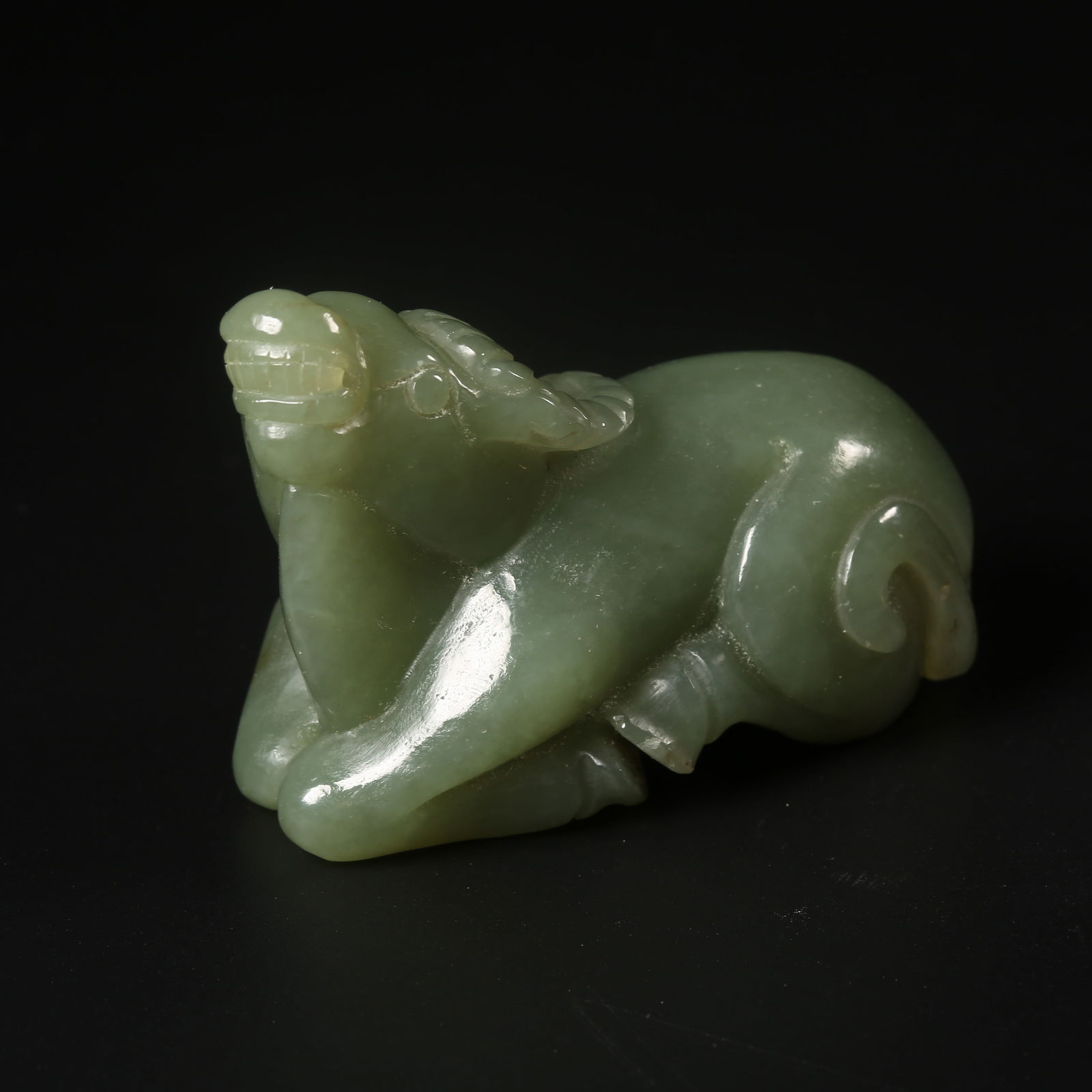A HETIAN SPINACH-GREEN JADE RECUMBENT OX ORNAMENT (1 of 8)