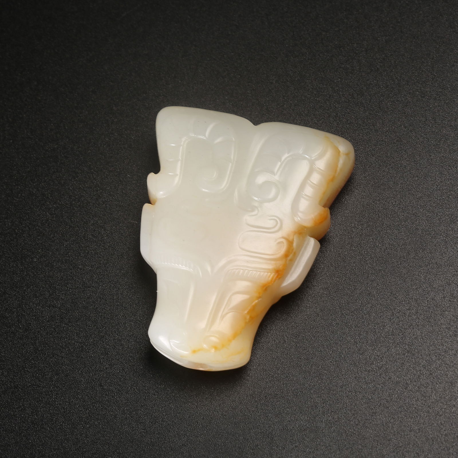 A ARCHAIC JADE PENDANT WITH OX-HEAD MOTIF (1 of 9)