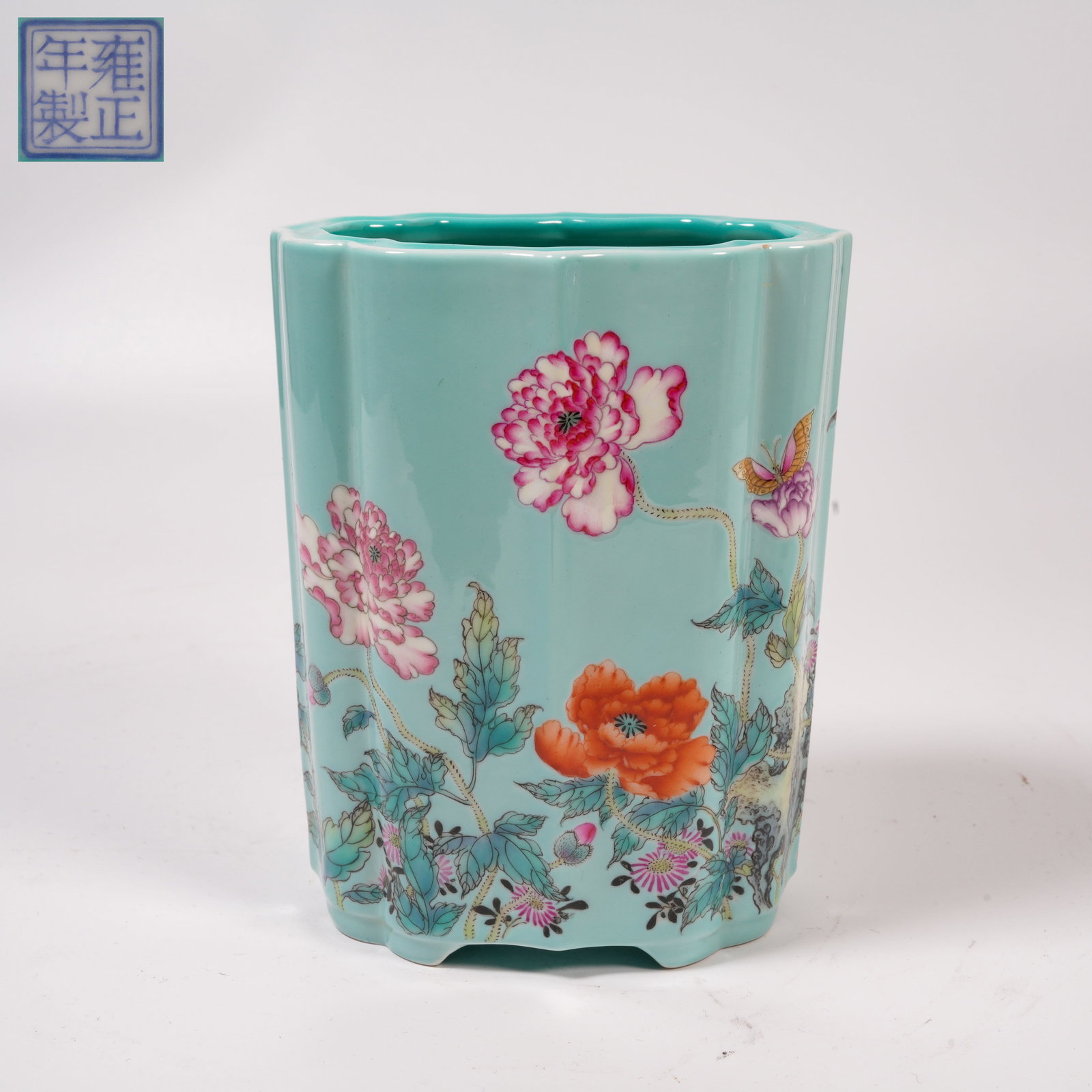 A TURQUOISE-GROUND FACETED BRUSH HOLDER WITH FAMILLE-ROSE FLOWER-AND-BUTTERFLY DESIGN: Turquoise-Ground Faceted Brush Holder with Famille-Rose Flower-and-Butterfly Design