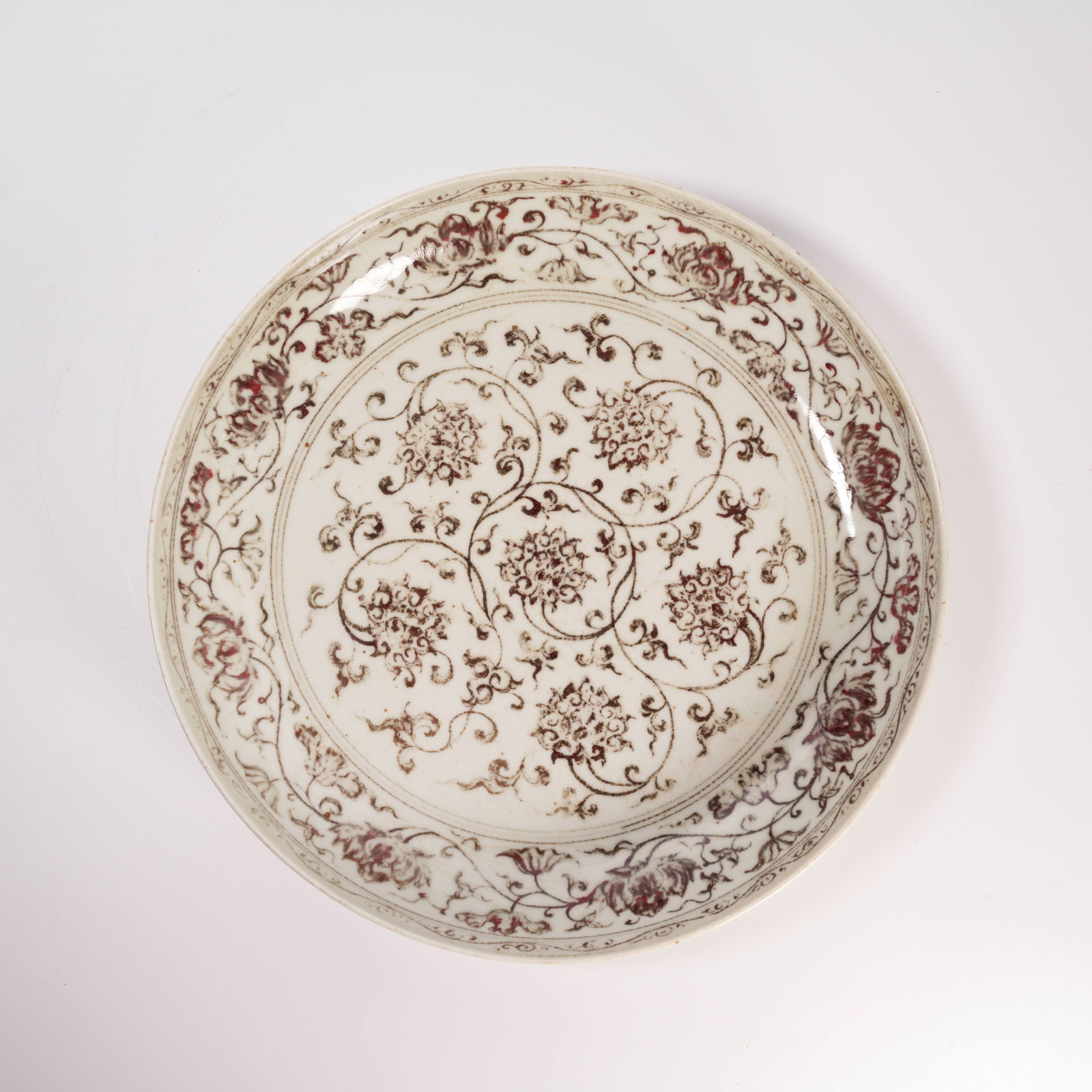 A UNDERGLAZE-RED PLATE WITH INTERTWINING FLORAL SCROLL DESIGN (1 of 7)