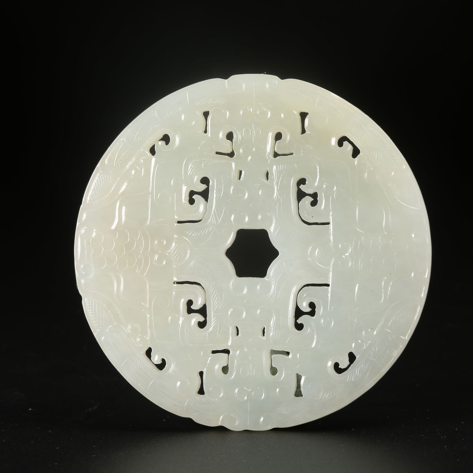 A HETIAN JADE BI DISC WITH ANIMAL-MASK MOTIF (1 of 9)