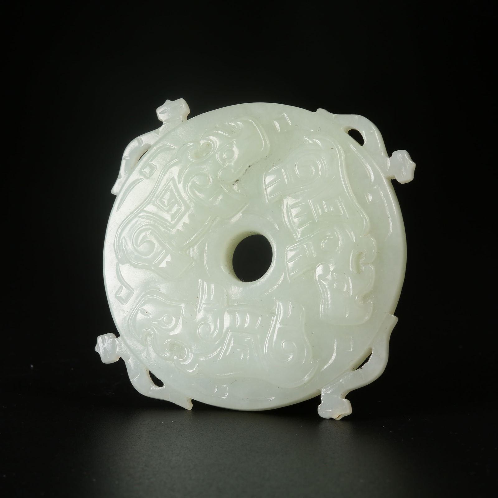 A ARCHAIC JADE BI DISC WITH RAISED BORDER AND AUSPICIOUS BEAST MOTIF (1 of 8)