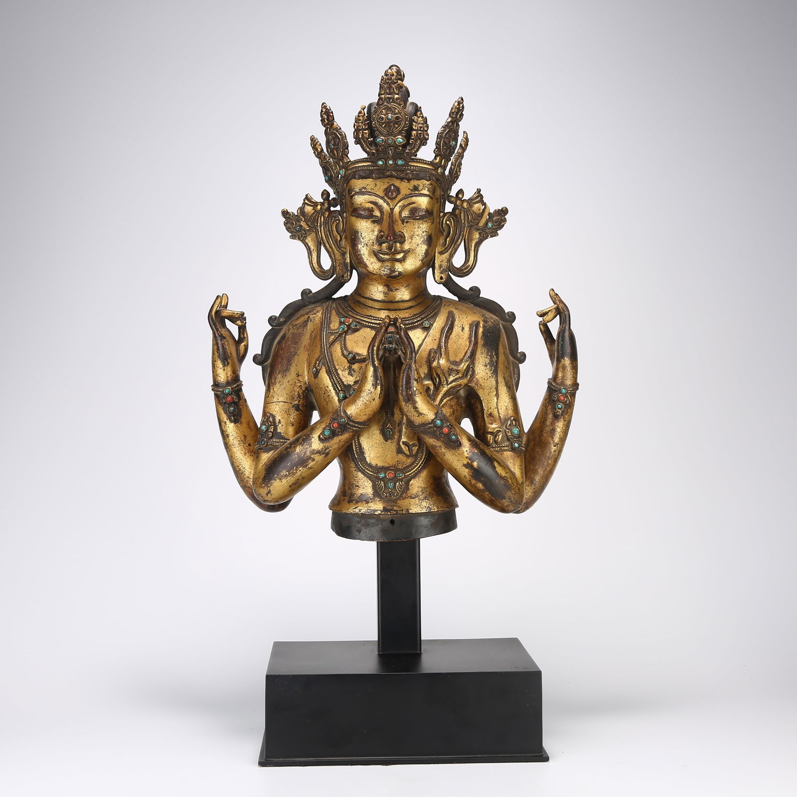 A GILDED BRONZE HALF-LENGTH STATUE OF FOUR-ARMED AVALOKITESHVARA: Gilded bronze half-length statue of four-armed Avalokiteshvara