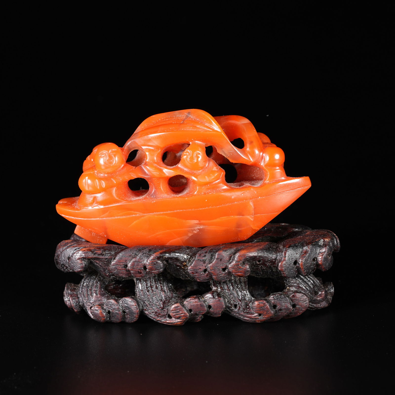 A SOUTHERN RED AGATE CARVED BOAT-AND-FIGURE ORNAMENT: Southern Red Agate Carved Boat-and-Figure Ornament