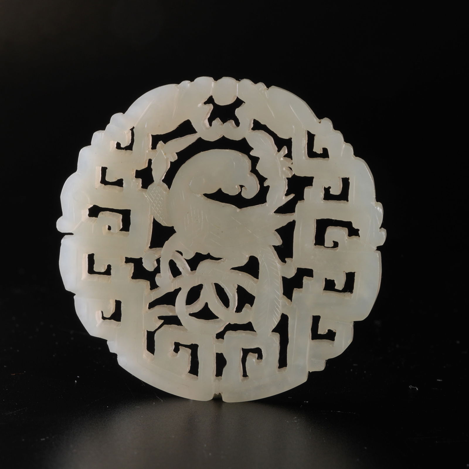 A HETIAN JADE CARVED PARROT-MOTIF PENDANT: Hetian jade carved parrot-motif pendant