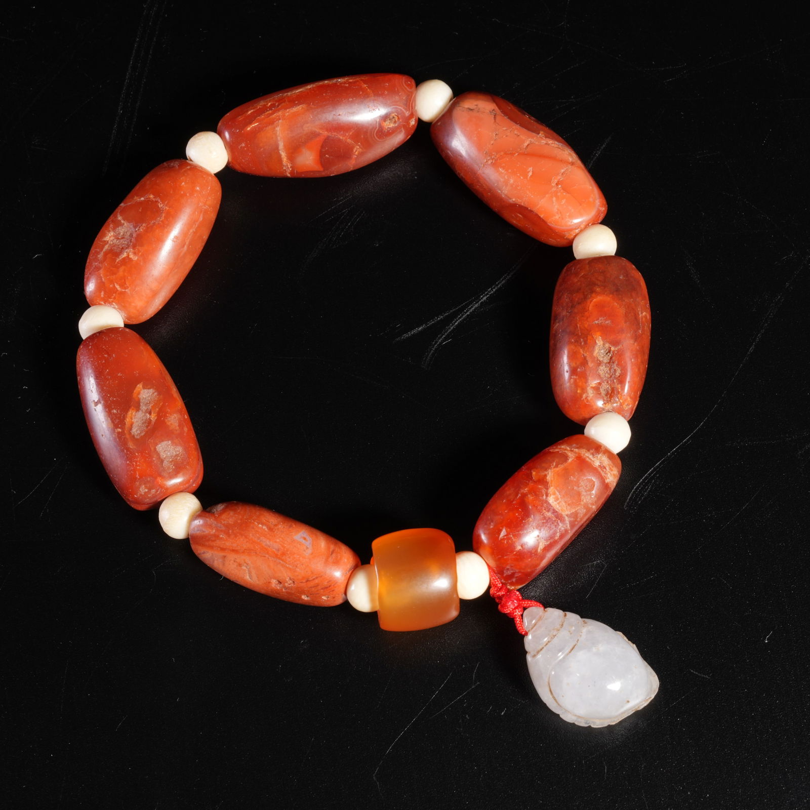A SOUTHERN RED AGATE CARVED BEAD BRACELET: Southern Red agate carved bead bracelet