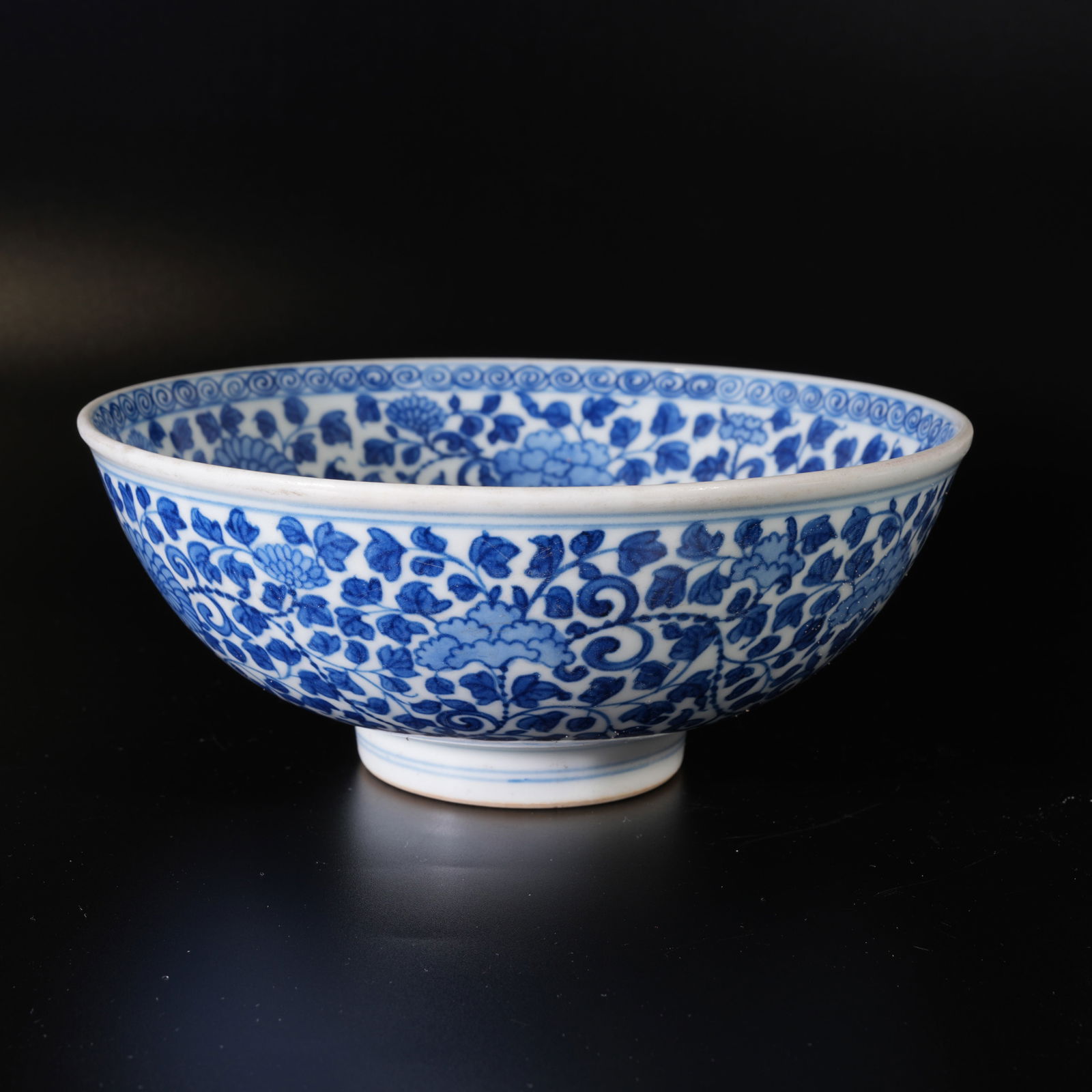 A BLUE-AND-WHITE BOWL WITH SCROLLING FLORAL DESIGN (1 of 11)