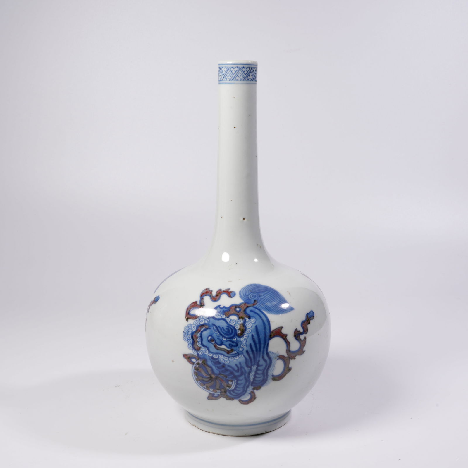 A BLUE-AND-WHITE AND UNDERGLAZE-RED LONG-NECKED VASE WITH LION AND EMBROIDERED BALL MOTIFS: Blue-and-white and underglaze-red long-necked vase with lion and embroidered ball motifs