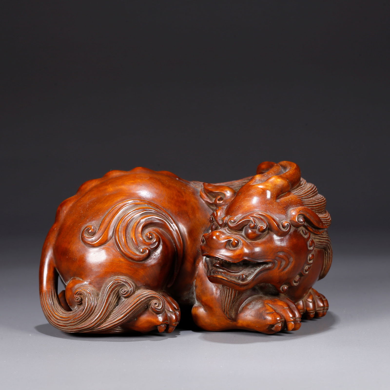 A HUANGHUALI WOOD CARVING OF A LION-SHAPED ORNAMENT: Huanghuali wood carving of a lion-shaped ornament