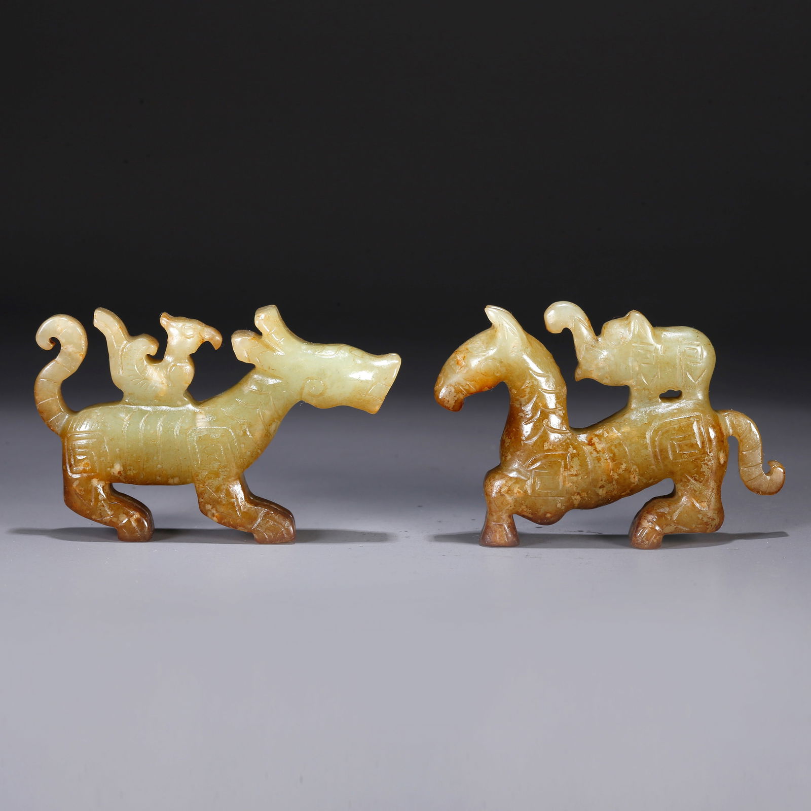 A PAIR OF ARCHAIC JADE ORNAMENTS CARVED IN AUSPICIOUS BEAST FORM: Pair of archaic jade ornaments carved in auspicious beast form