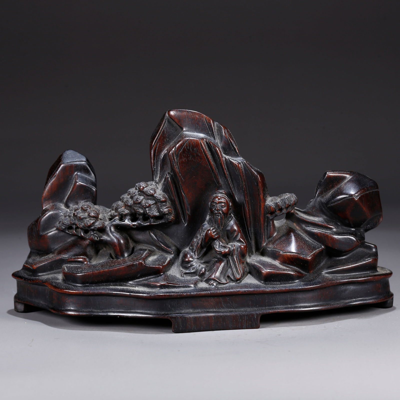 A ZITAN WOOD CARVING OF A MOUNTAIN SCENE WITH FIGURES ORNAMENT: Zitan wood carving of a mountain scene with figures ornament