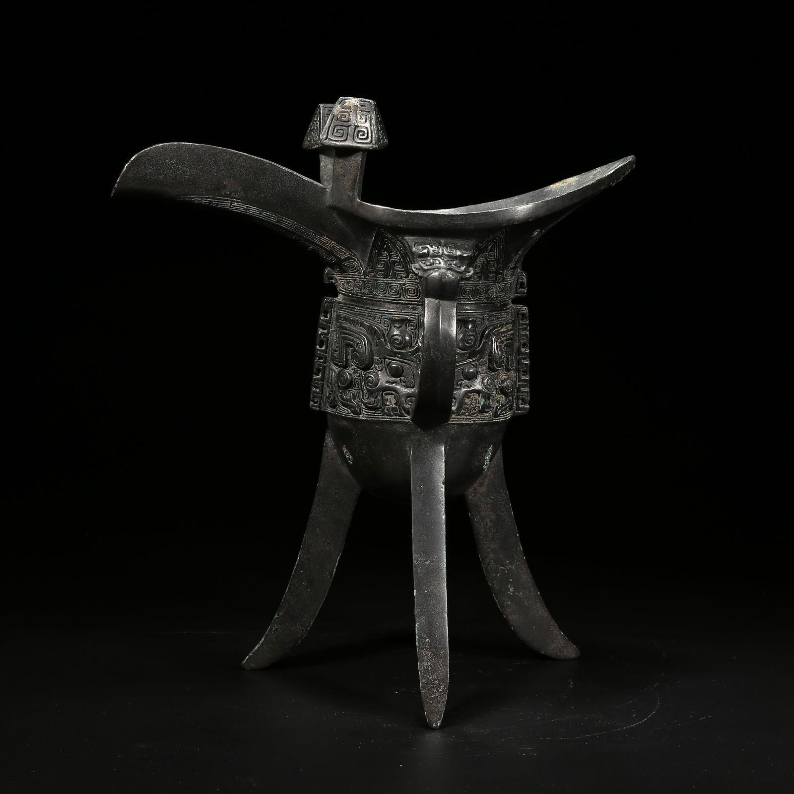 A BRONZE JUE CUP WITH TAOTIE (BEAST FACE) PATTERN: Bronze jue cup with taotie (beast face) pattern