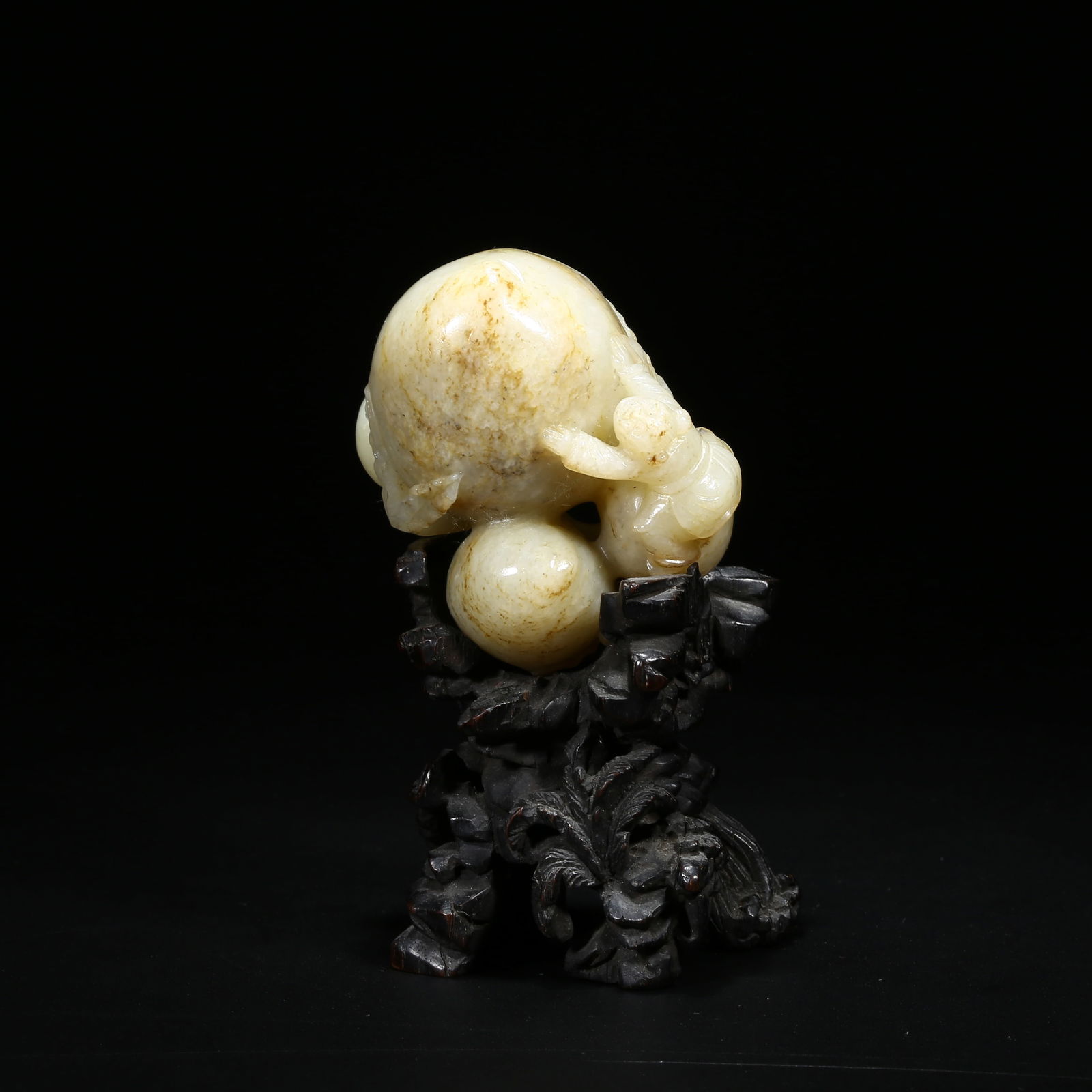 A HETIAN WHITE JADE FIGURINE OF A CHILD PRESENTING LONGEVITY: Hetian white jade figurine of a child presenting longevity