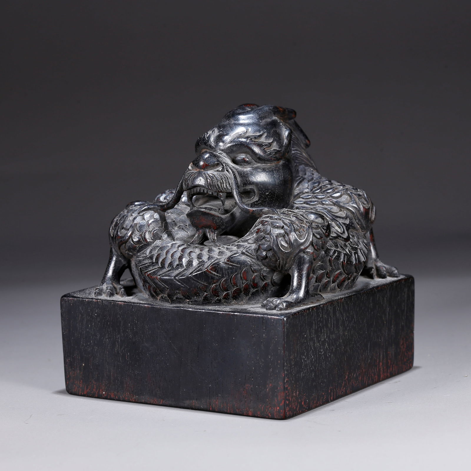 A ZITAN WOOD CARVING OF A CHI DRAGON-KNOB SEAL: Zitan wood carving of a chi dragon-knob seal