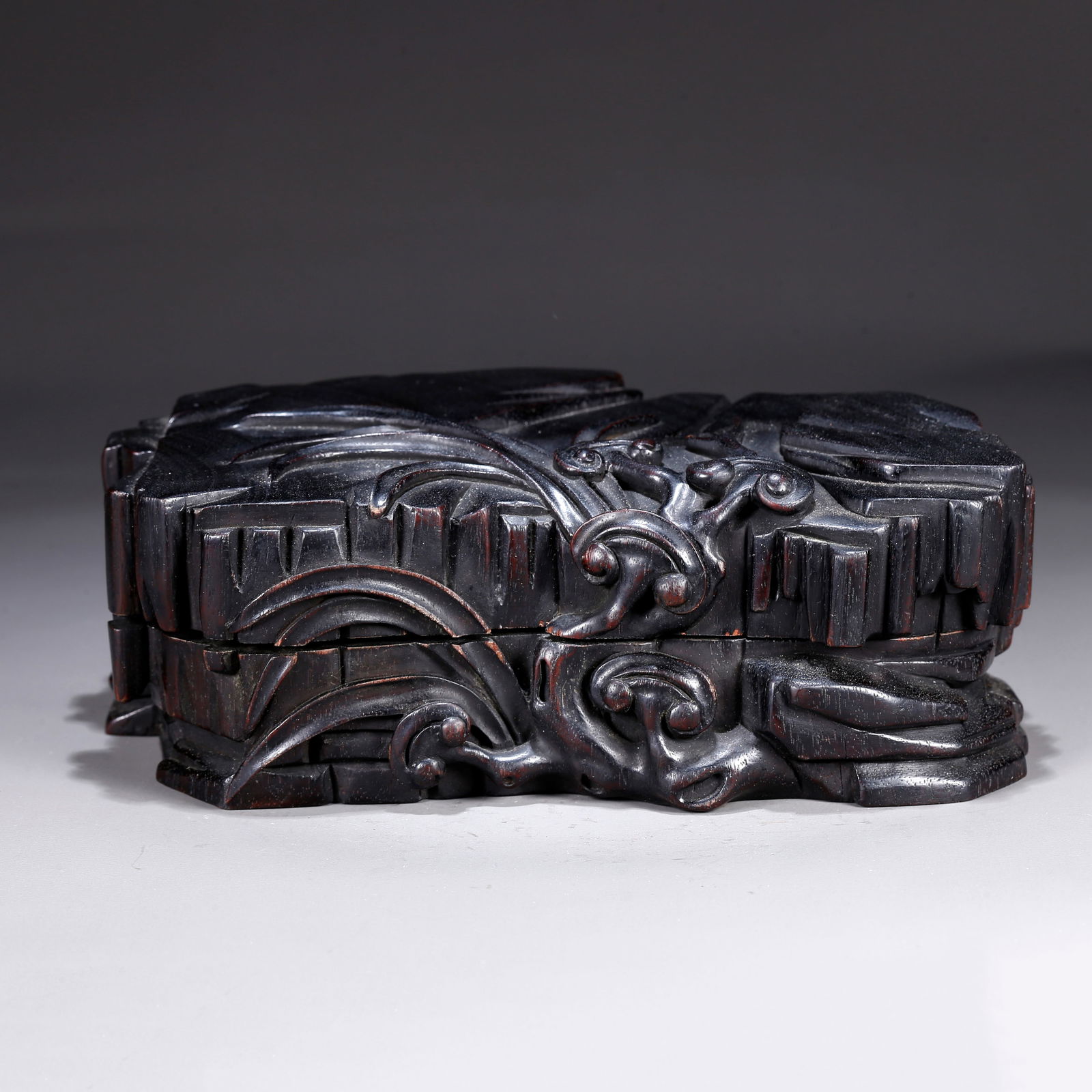 A ZITAN WOOD CARVING OF A LINGZHI-PATTERNED LIDDED BOX: Zitan wood carving of a lingzhi-patterned lidded box