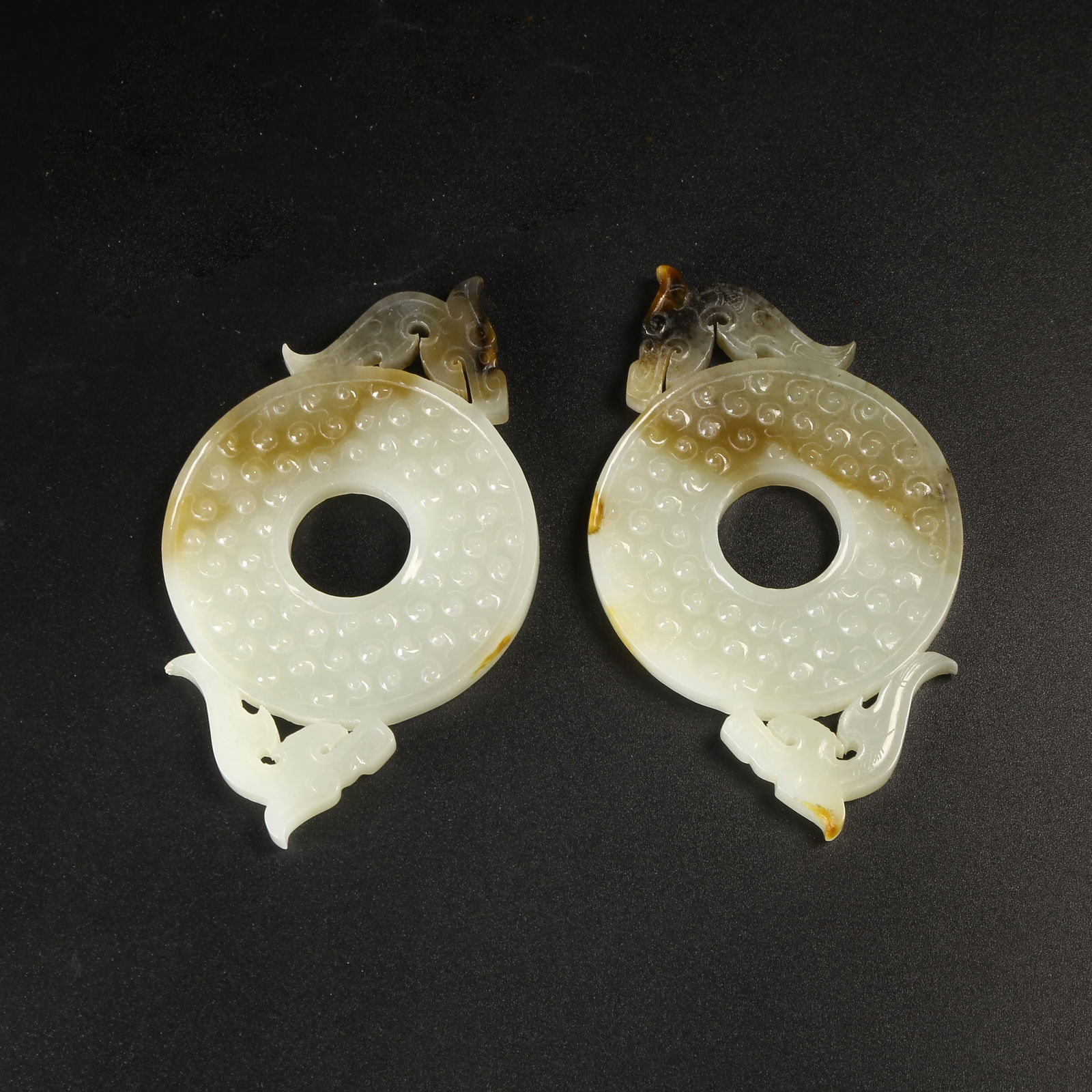 A ARCHAIC JADE DRAGON-HEAD BI DISC WITH RAISED BORDER: Archaic Jade Dragon-Head Bi Disc with Raised Border