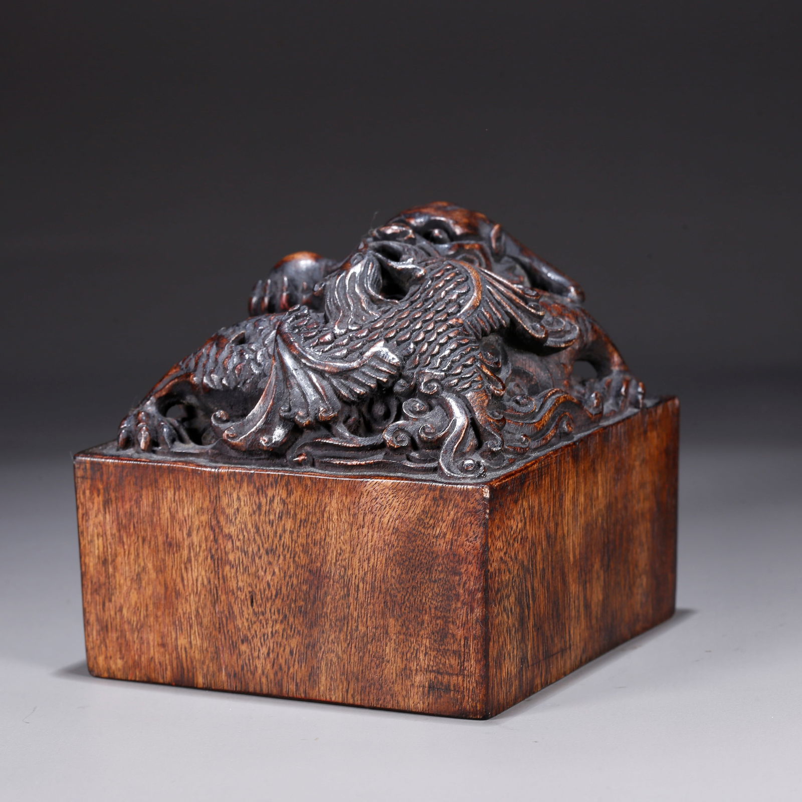 A HUANGHUALI WOOD CARVING OF A DRAGON AND PHOENIX-KNOB SEAL: Huanghuali wood carving of a dragon and phoenix-knob seal