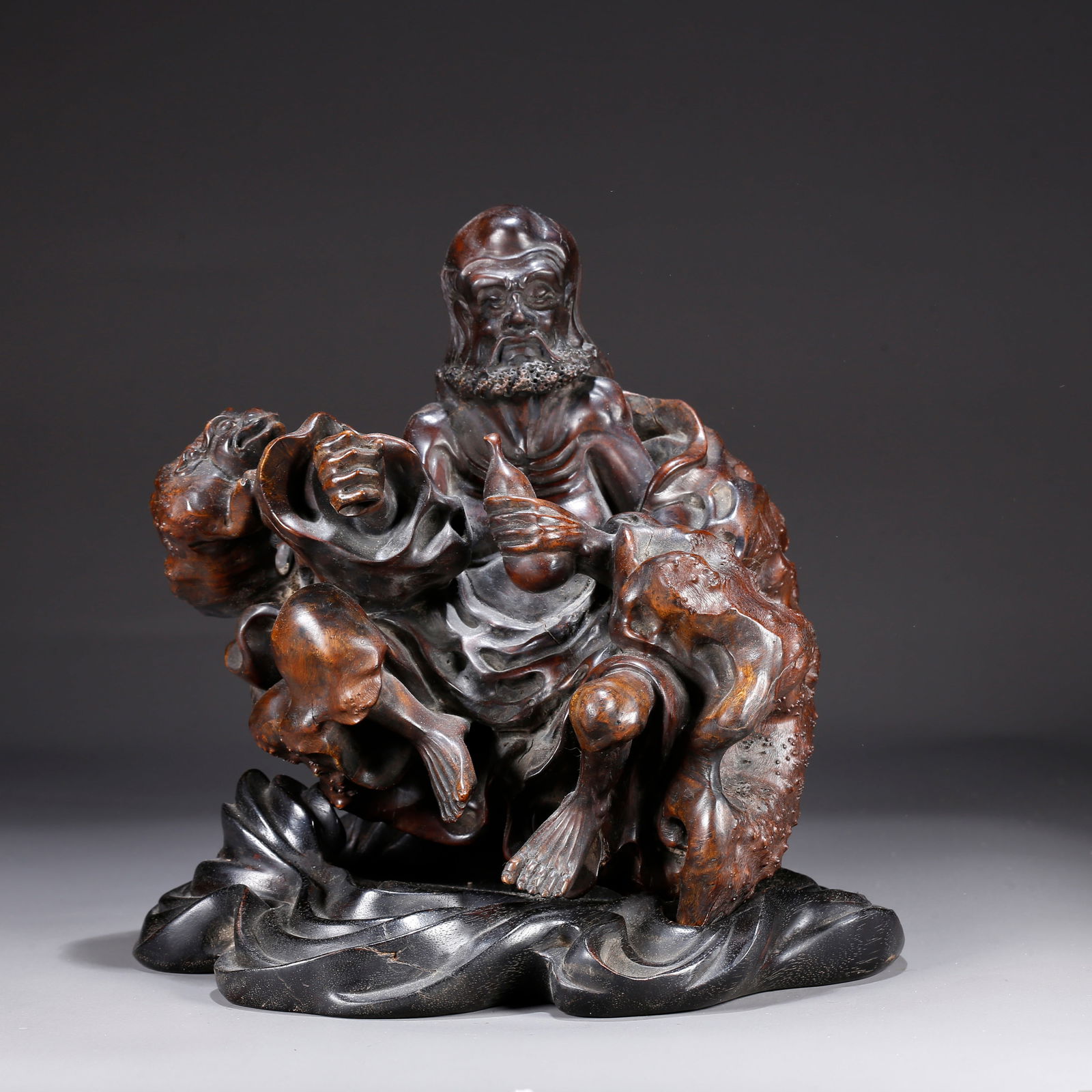 A HUANGHUALI WOOD CARVING OF A FIGURE-SHAPED ORNAMENT (1 of 9)