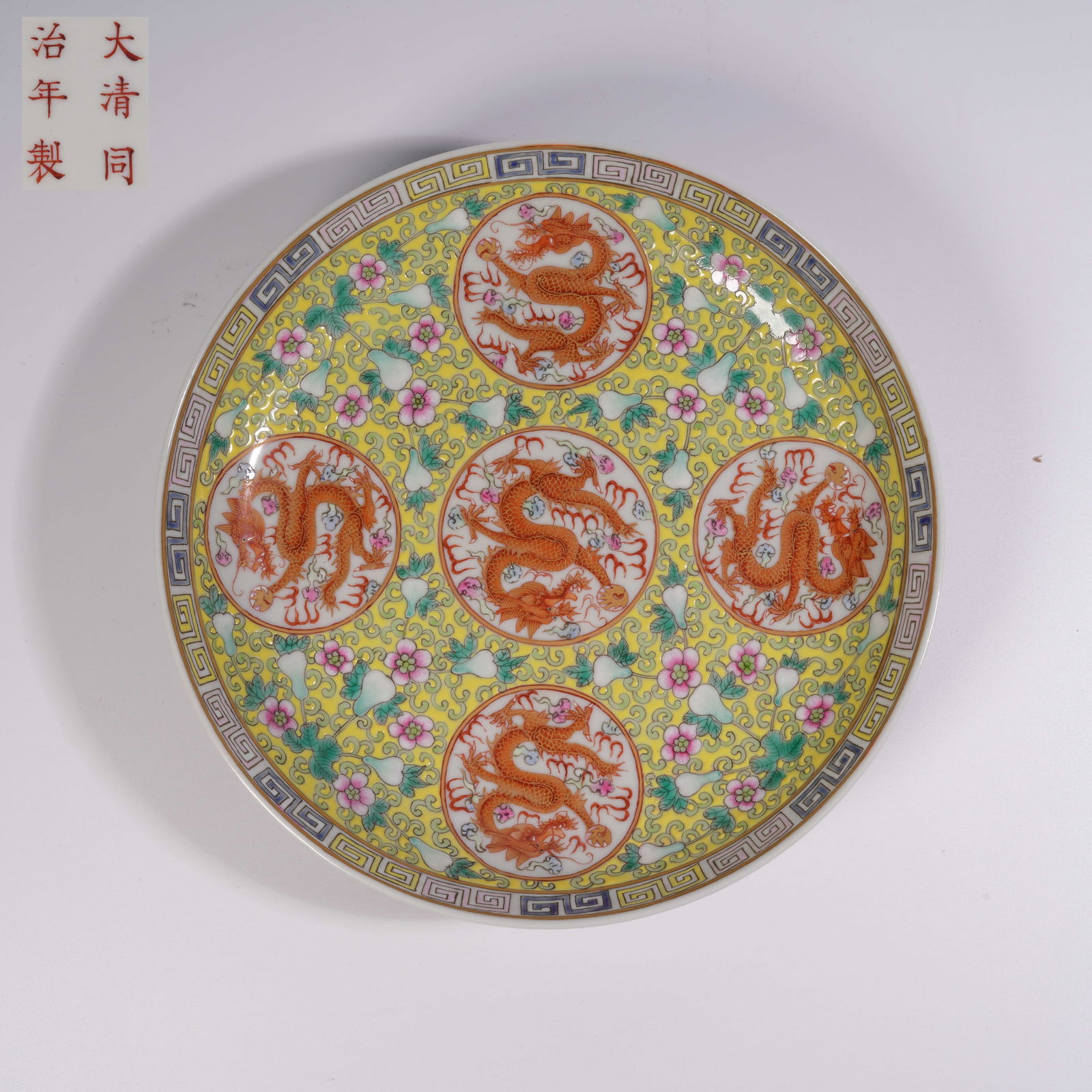 A YELLOW-GROUND PLATE WITH WINDOW PANELS AND IRON-RED DRAGON MOTIFS: Yellow-ground plate with window panels and iron-red dragon motifs