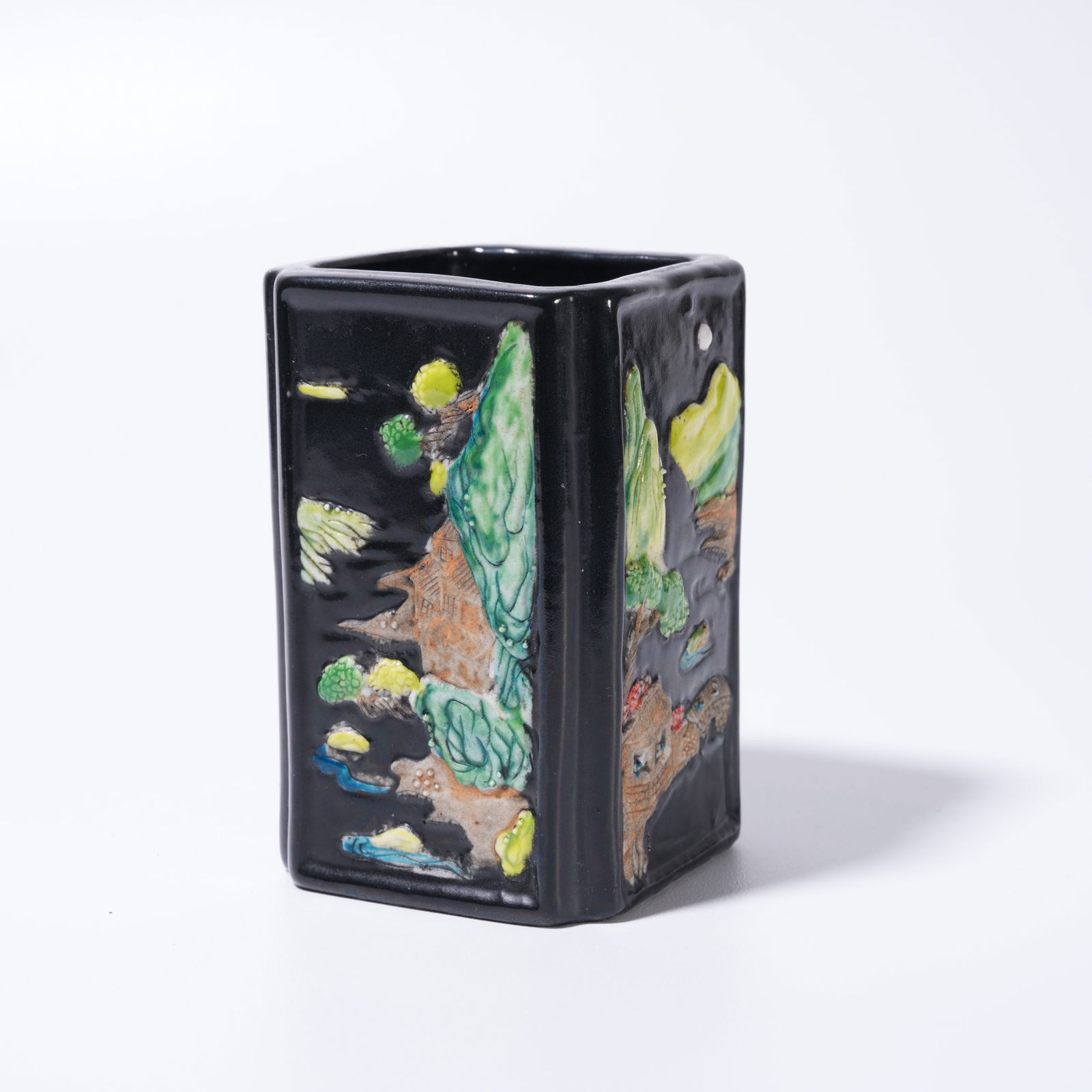 A BLACK-GROUND FAMILLE ROSE LANDSCAPE-PATTERN BRUSH HOLDER: Black-Ground Famille Rose Landscape-Pattern Brush Holder