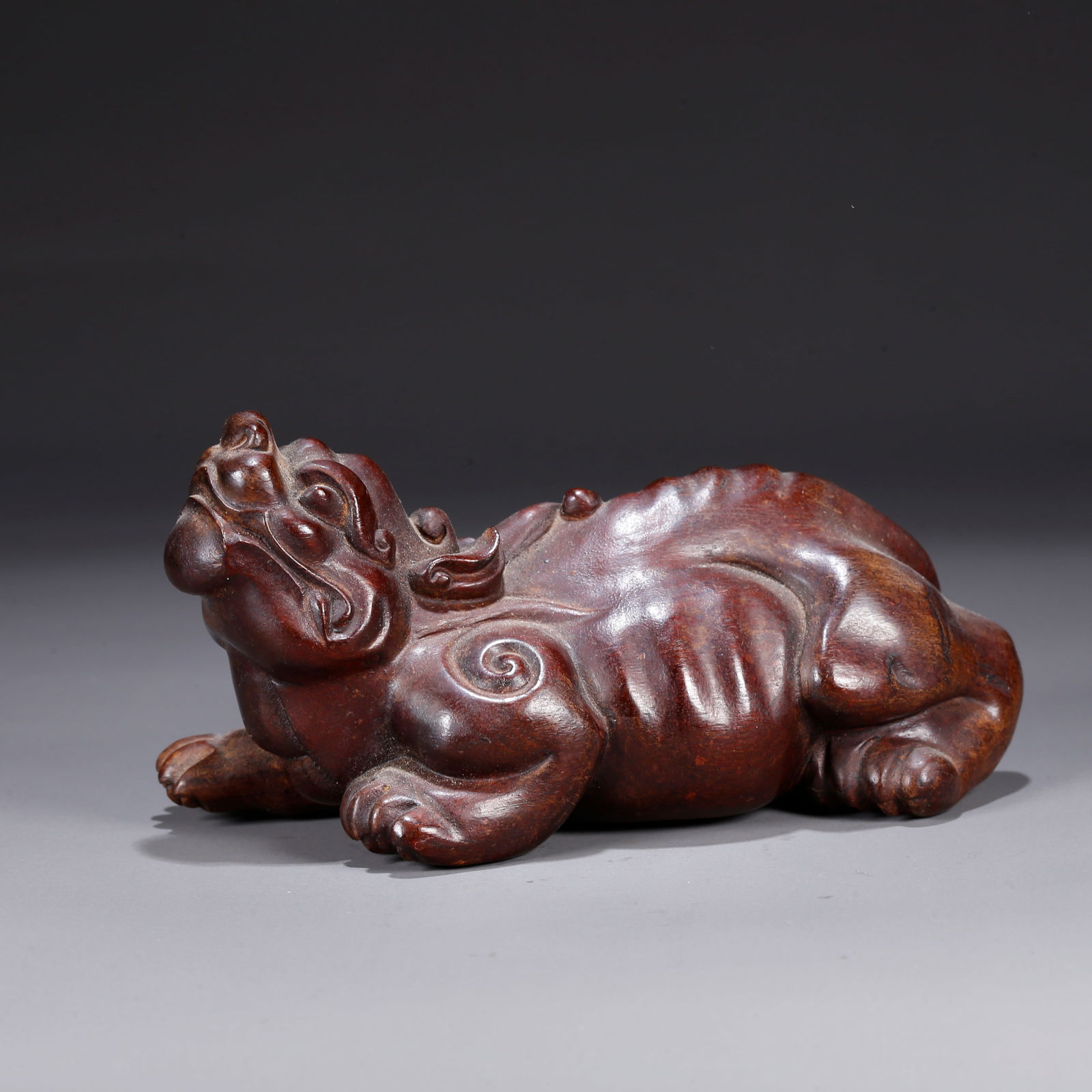 A HUANGHUALI WOOD CARVING OF A LION-SHAPED ORNAMENT: Huanghuali wood carving of a lion-shaped ornament