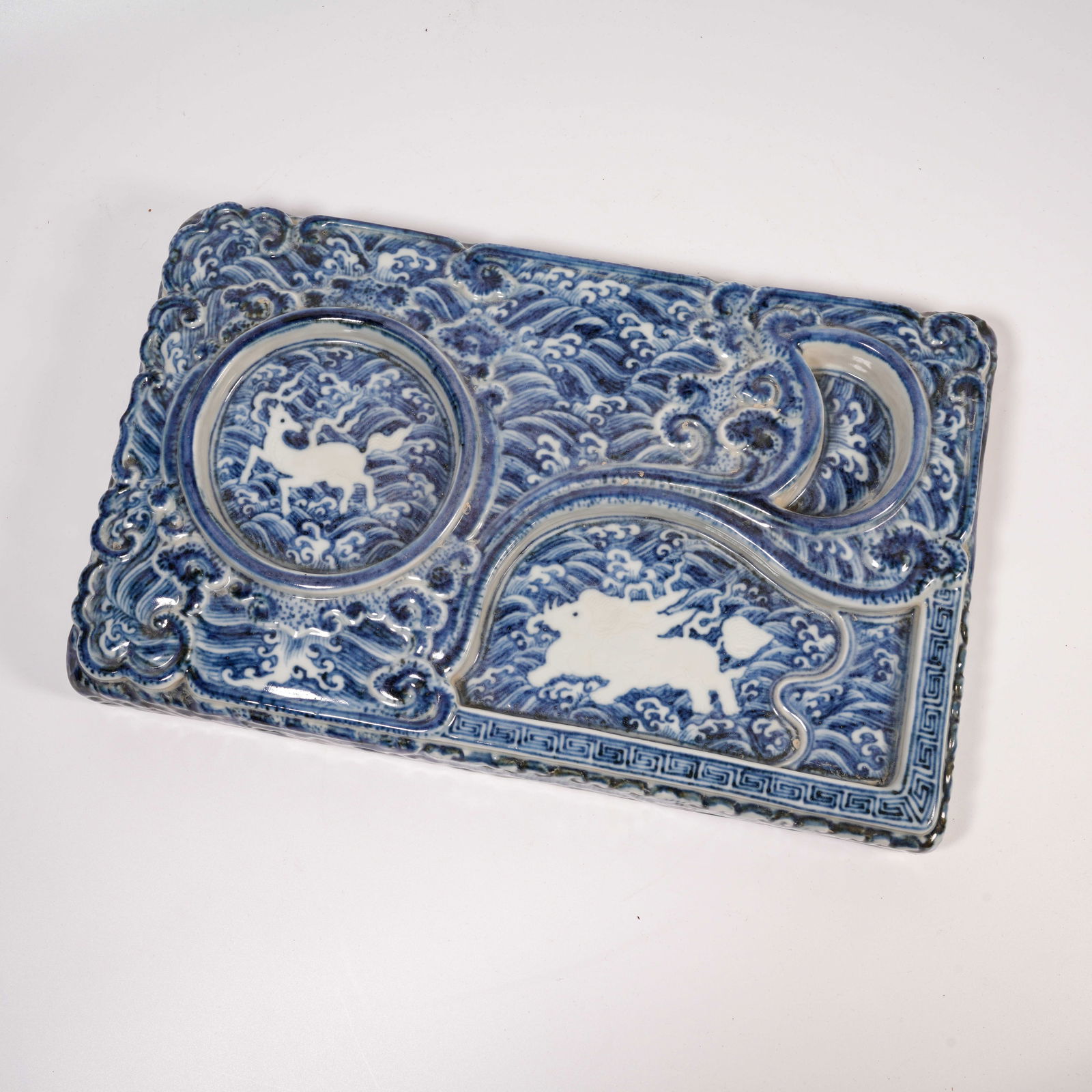 A BLUE-AND-WHITE INKSTONE WITH CARVED SEA-BEAST DESIGN: Blue-and-White Inkstone with Carved Sea-Beast Design